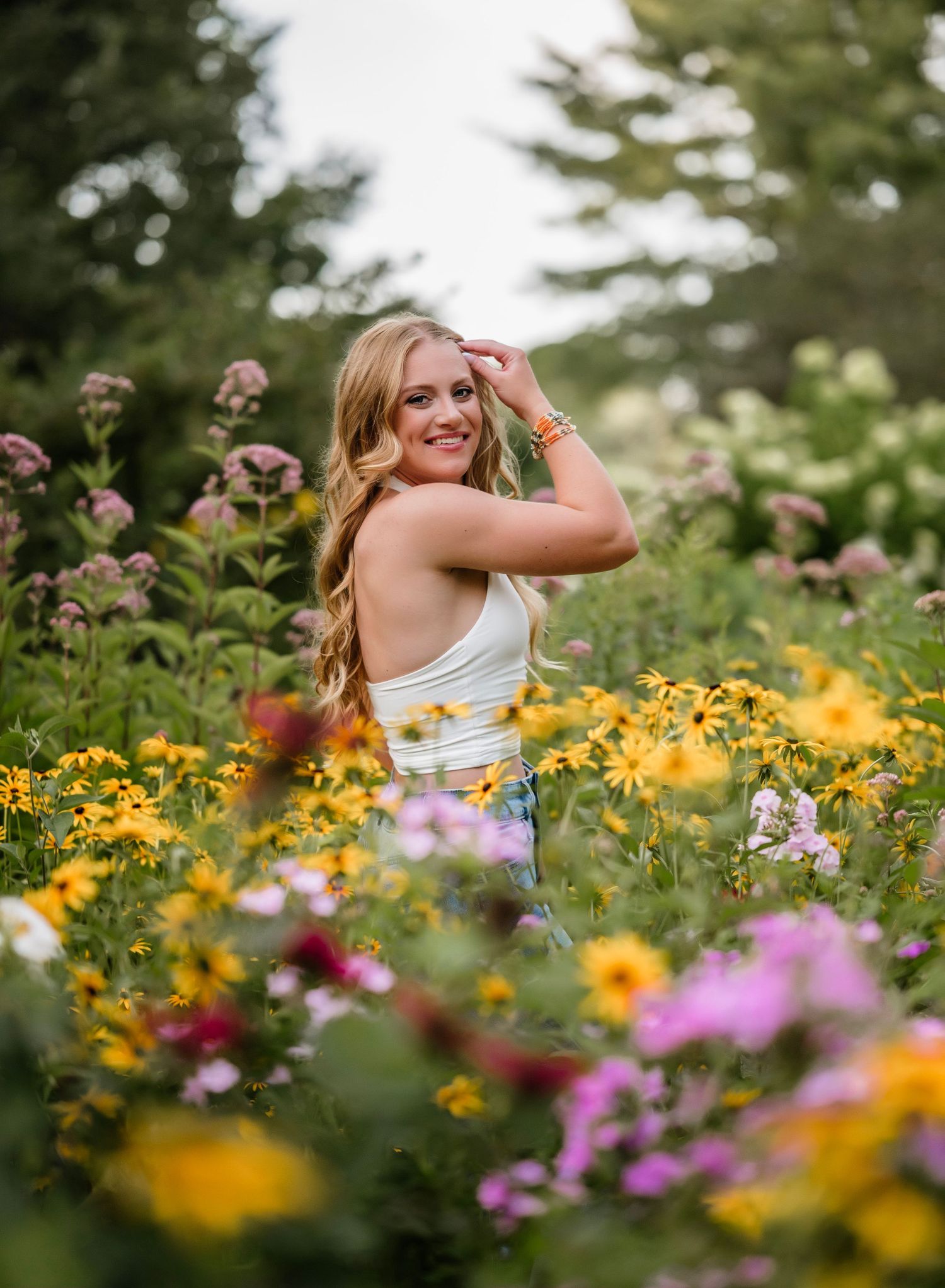 A series of photos showing someone posing in a vibrant wildflower garden filled with yellow and pink blooms.