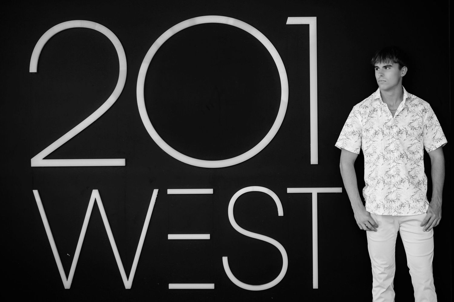 A series of black and white photos showing someone posing in different outfits against a dark background.