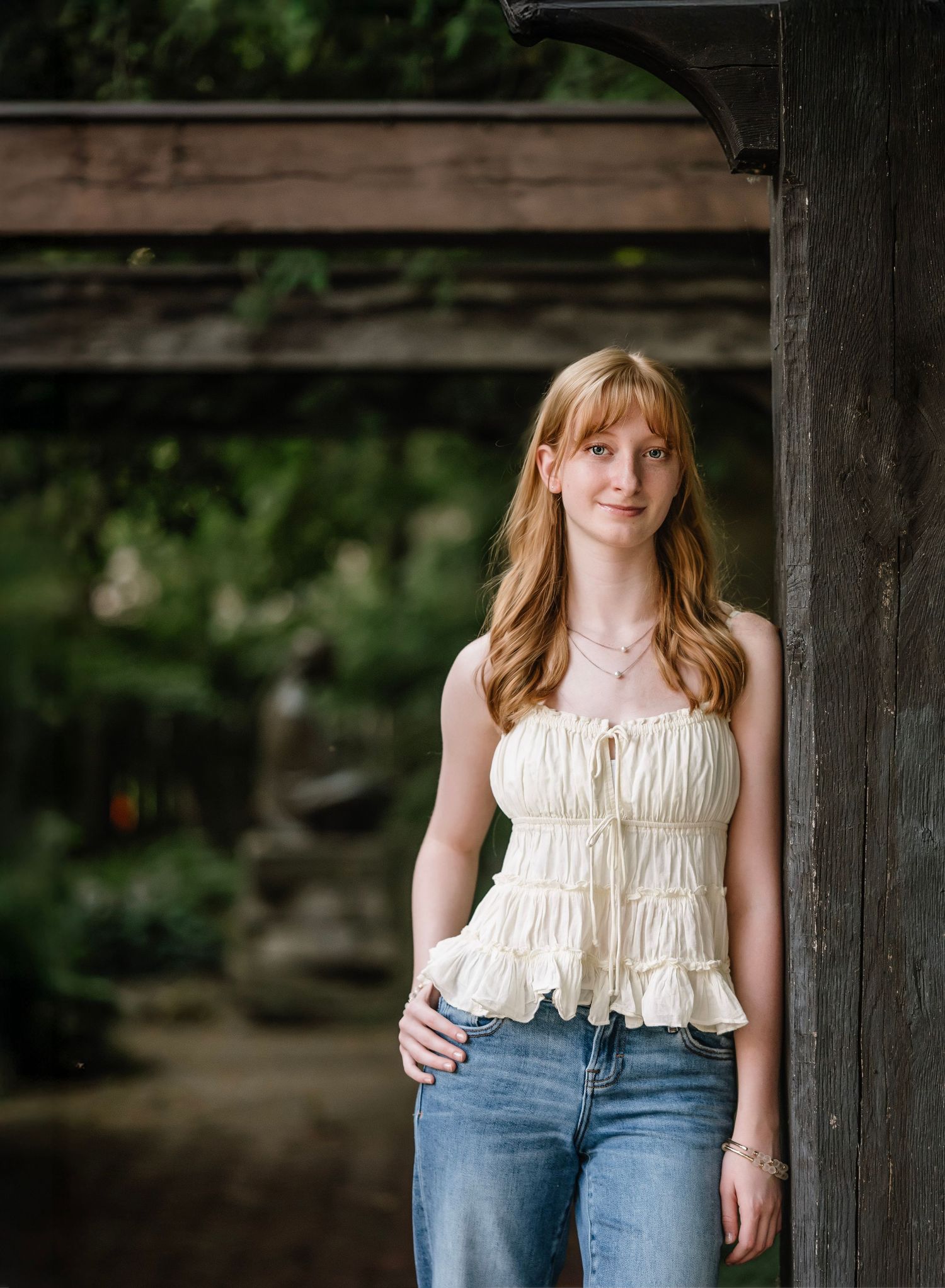 A series of portraits showing a person in a cream ruffled top and blue jeans posing against a rustic wooden backdrop.