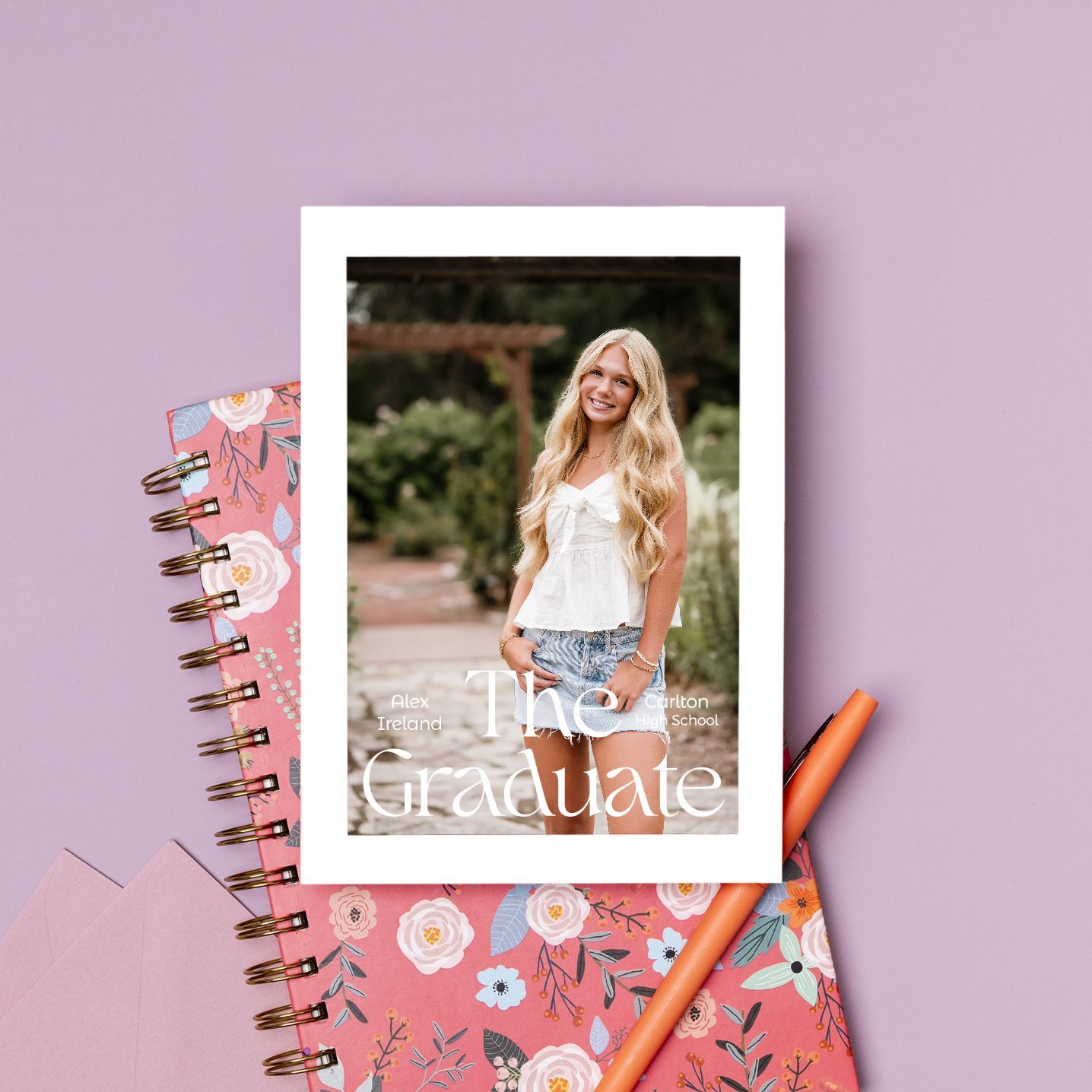 Pink spiral notebook with floral decorations and stationery items arranged on pastel background for back to school concept.
