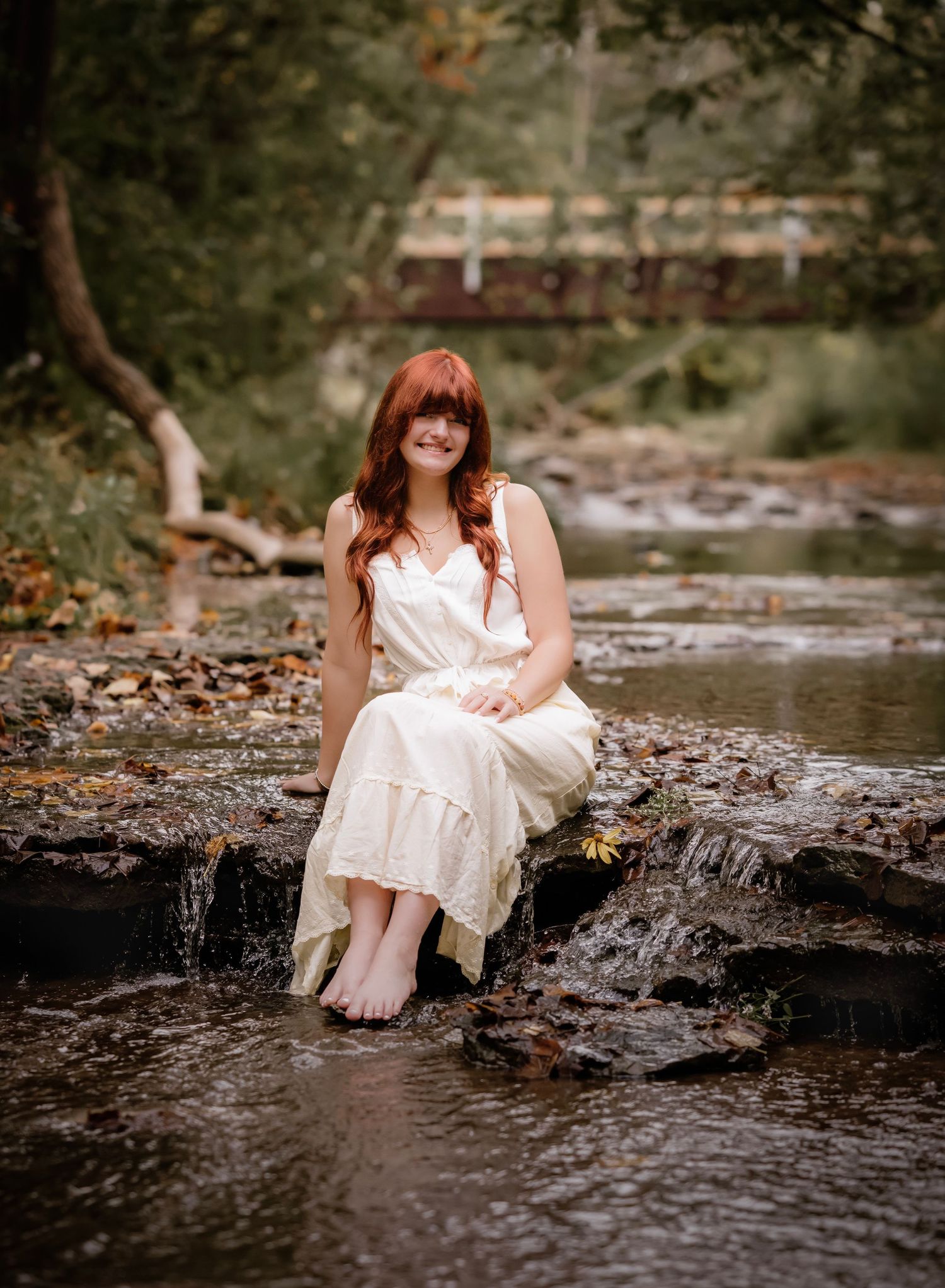 A series of dreamy creek-side portraits showing someone in a white dress sitting on rocks by flowing water.