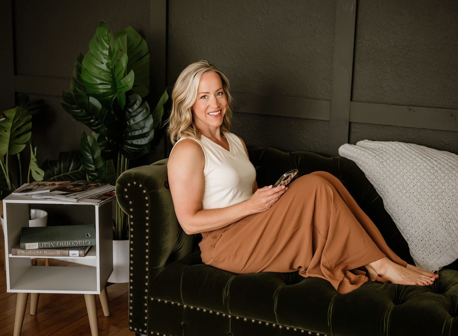 Lifestyle branding photography series showcasing casual outfits on a dark gray couch with tropical decor.