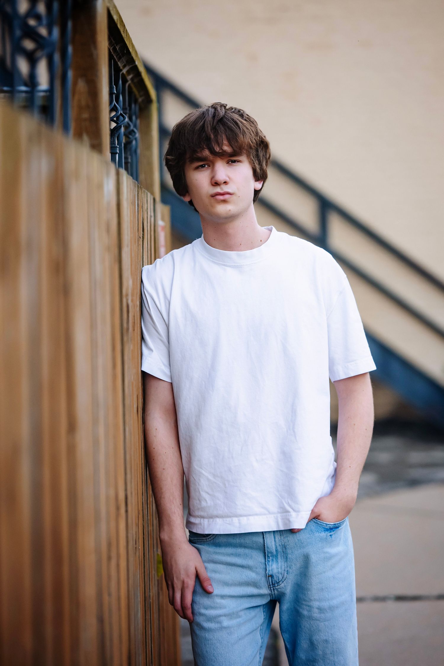 A series of photos showing someone wearing a white t-shirt and light blue jeans standing against a wooden railing.