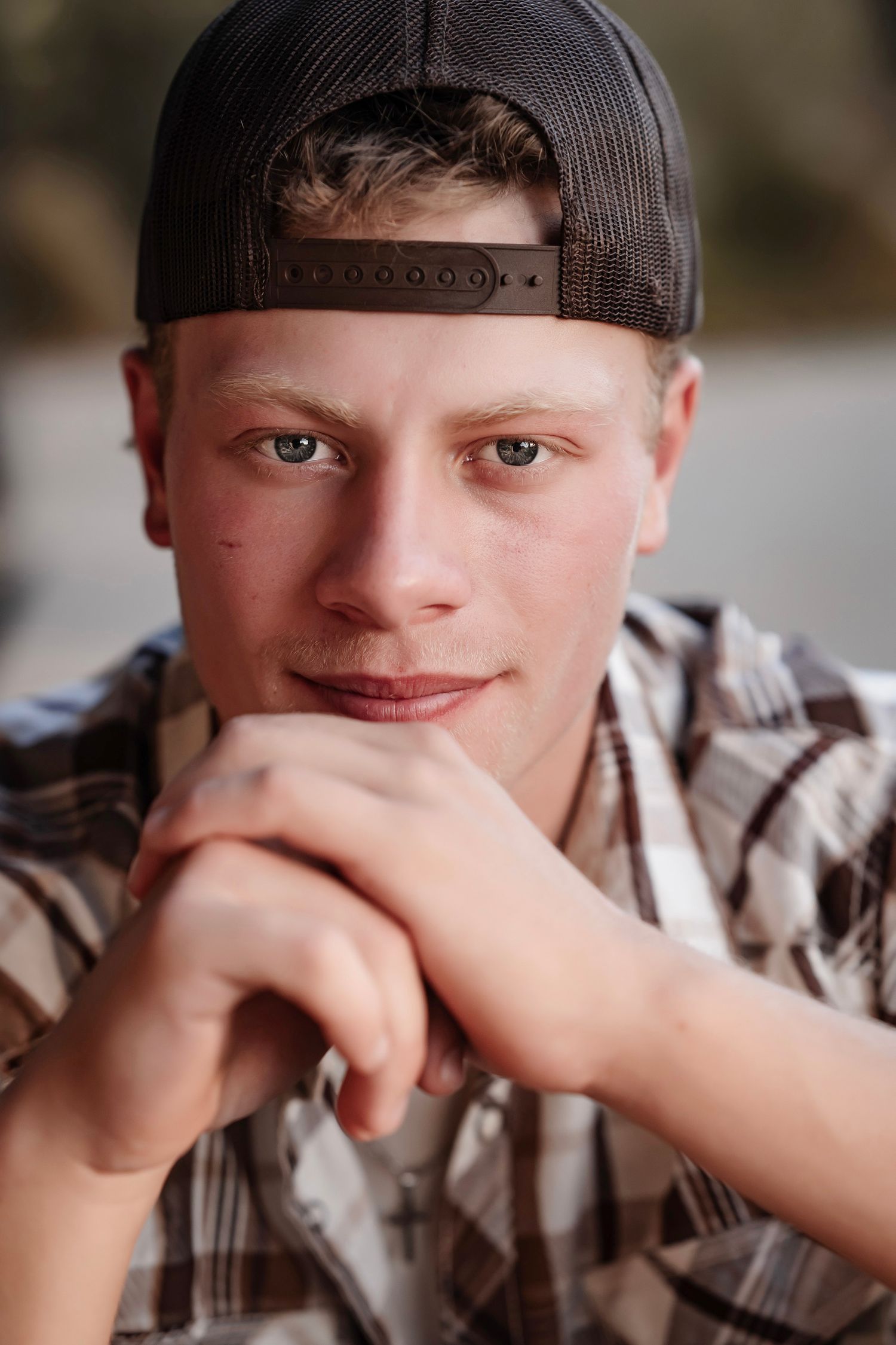 A series of four connected photos showing someone in a plaid shirt and cap making playful expressions.