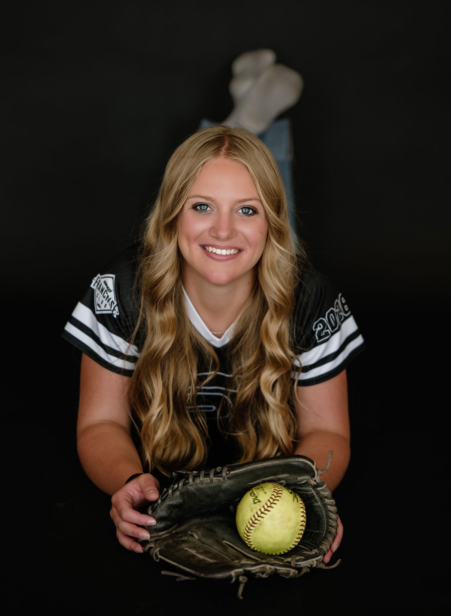 A series of softball player portraits against a dark background showing poses with glove and yellow softball.