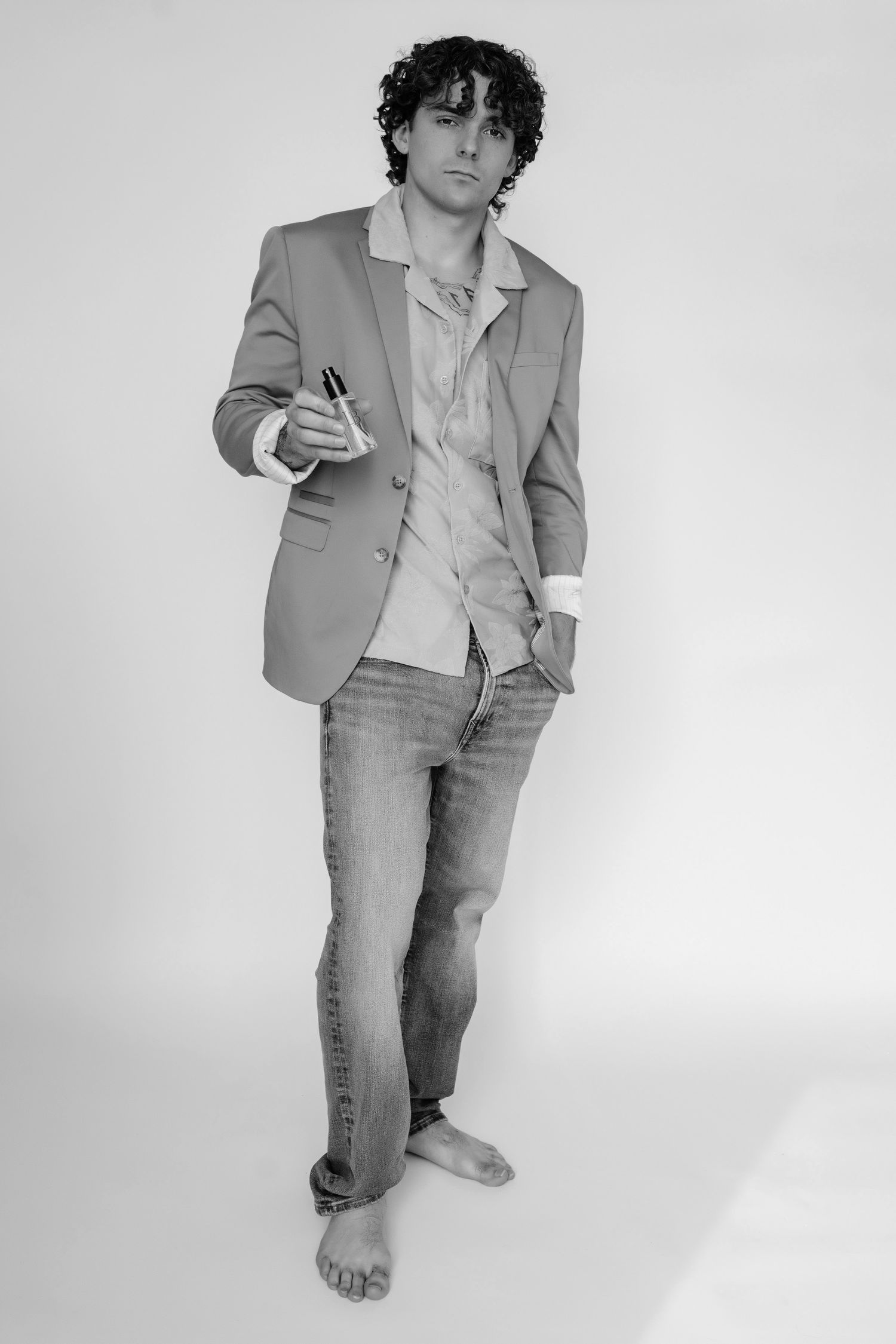 A person in a light gray suit poses in various positions against a white background in a minimalist fashion photoshoot.