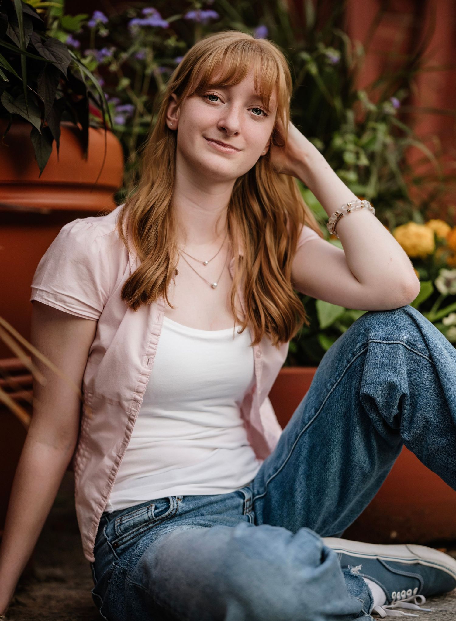 Casual outdoor portrait series showing someone relaxing in denim and pink attire against a garden background.