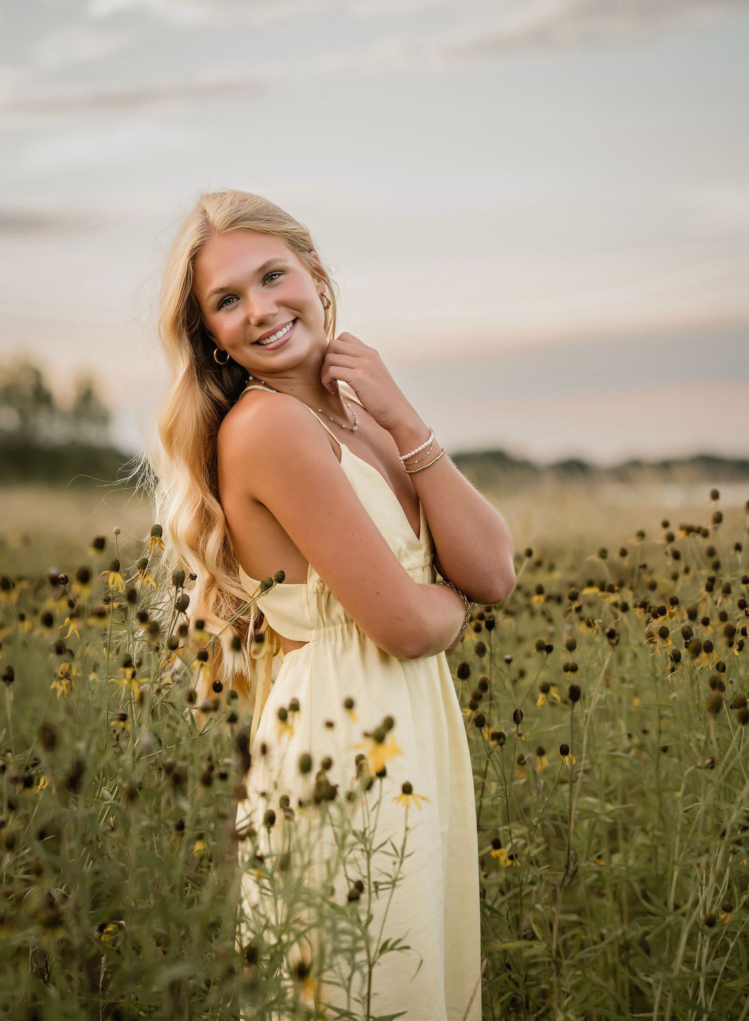 A dreamy sunset portrait session in a field of black-eyed susans and wildflowers during golden hour.