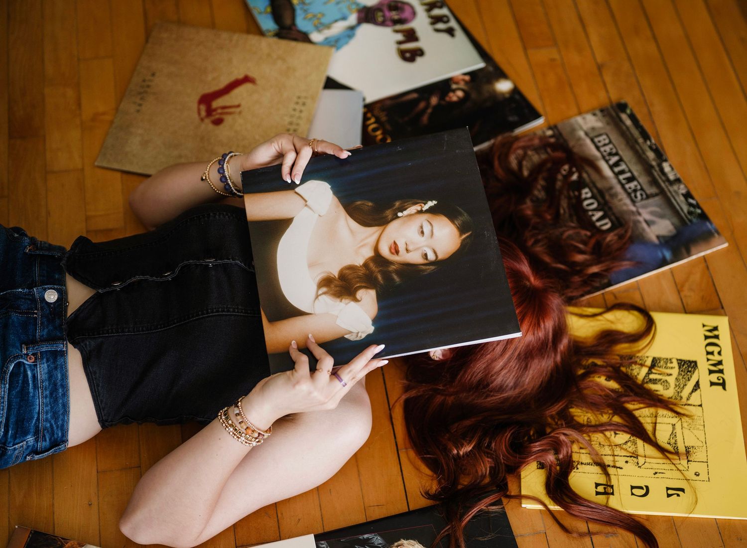 A sequence of photos shows someone lying on a hardwood floor posing for artistic portraits.