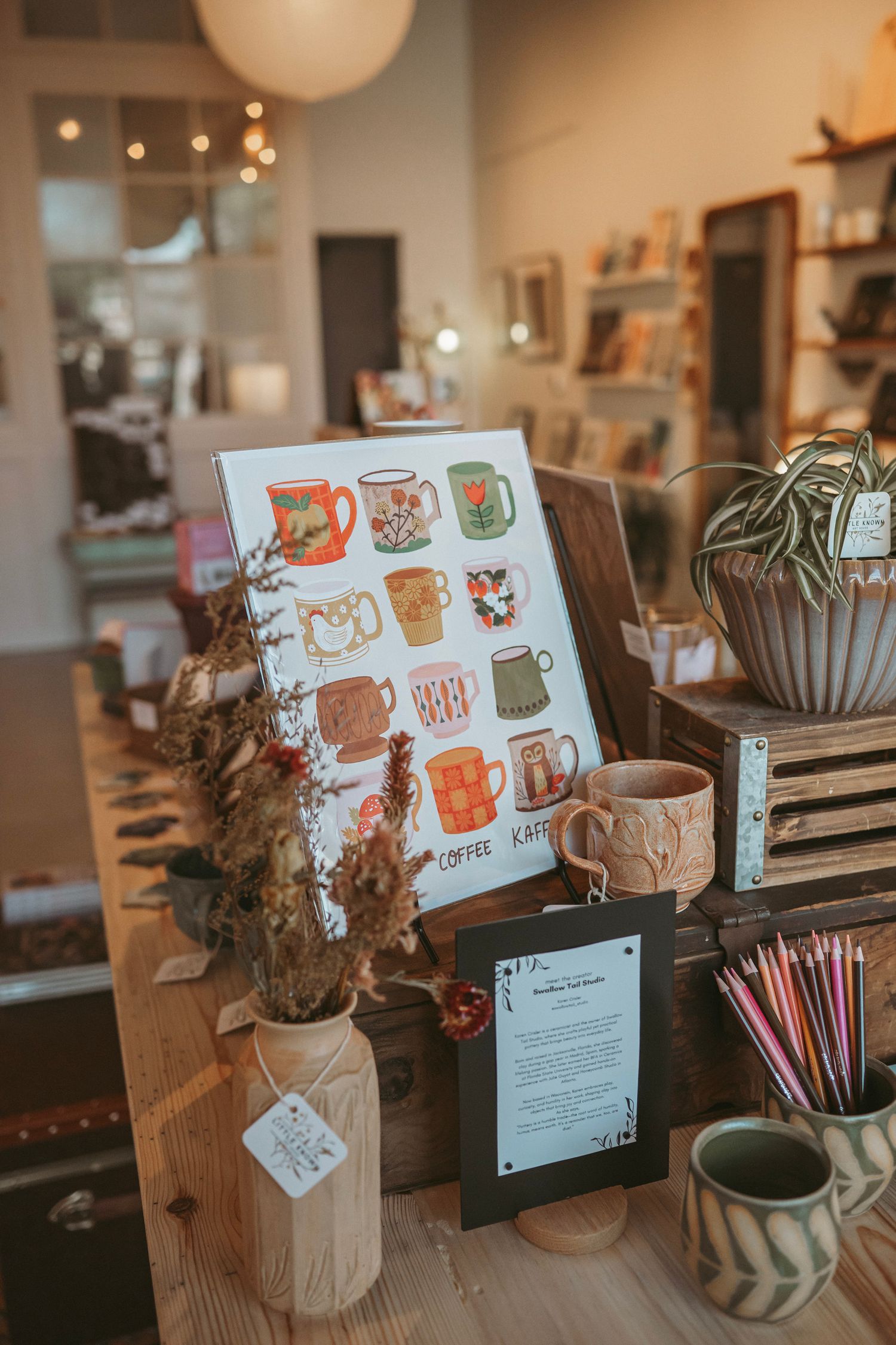 Cozy coffee shop counter display with illustrated menu cards, decorative mugs, and ambient lighting.