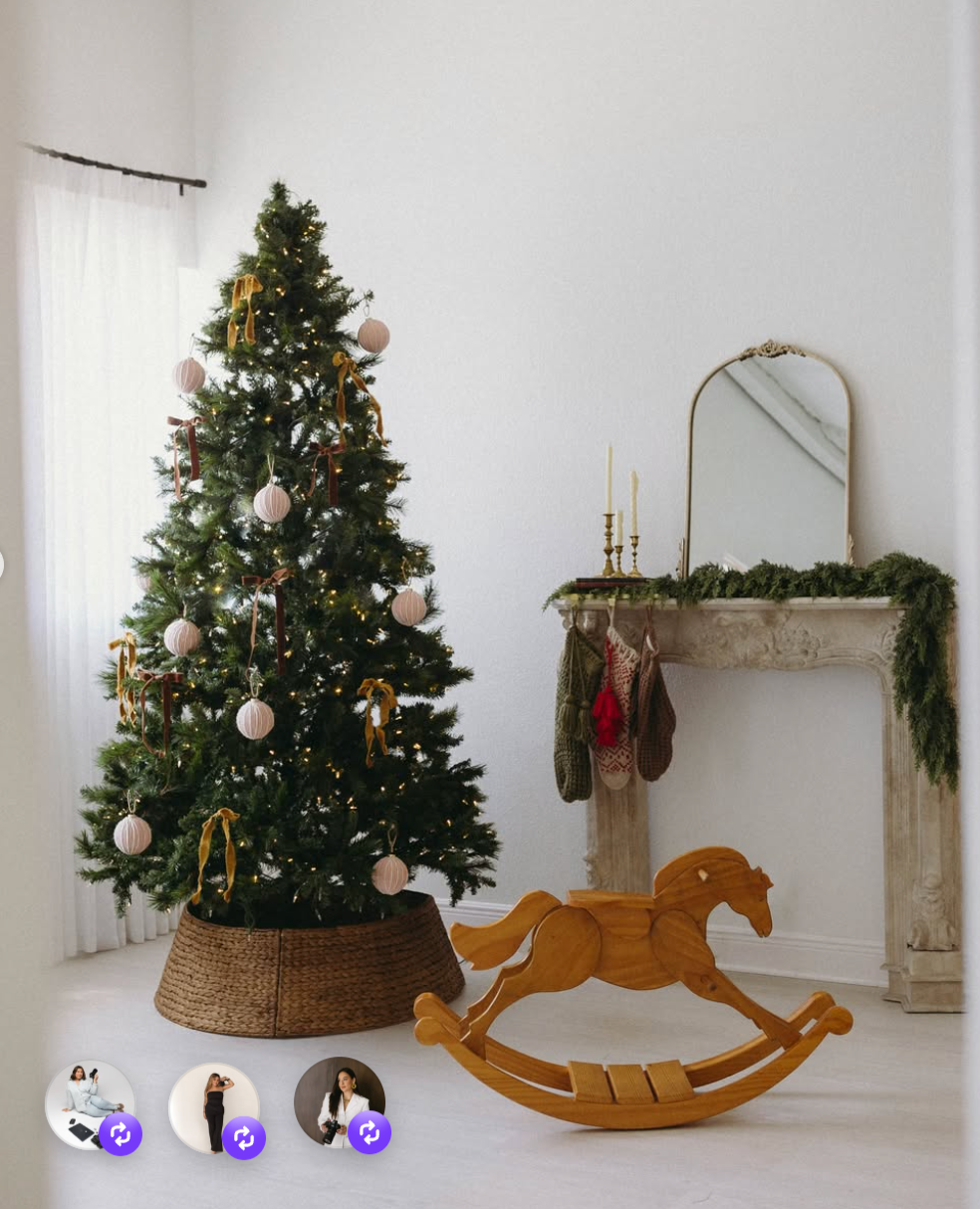 Festive Christmas tree with pink ornaments beside a wooden rocking horse and garland-draped fireplace in a white room.