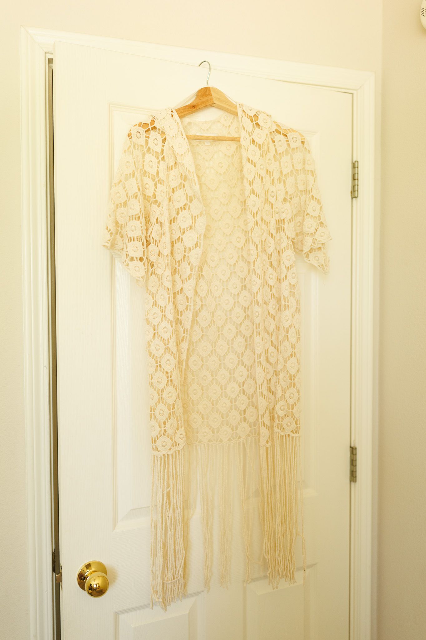 Three identical cream-colored macrame wall hangings with geometric patterns displayed against a white wall.