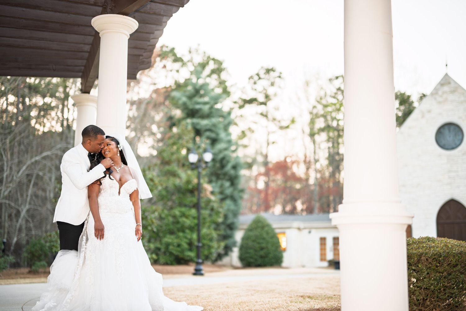 An elegant wedding venue with white columns and landscaped grounds.