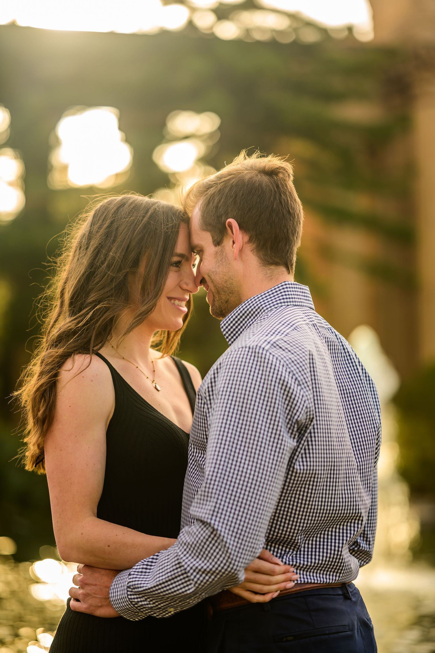 A romantic sunset photoshoot showing tender moments between a couple in casual attire.