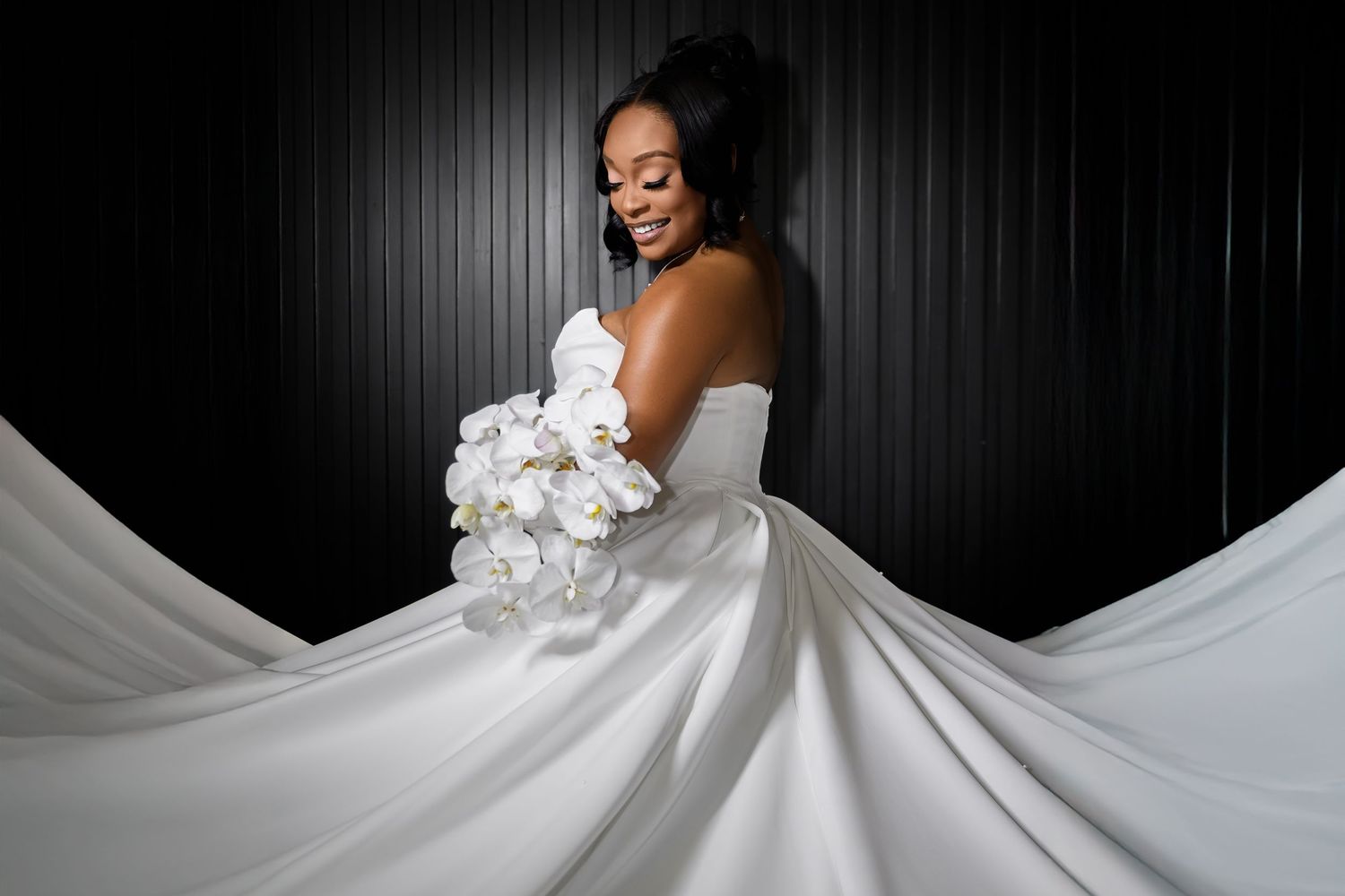 A bride in a flowing white ball gown twirls gracefully against a dark background, creating a stunning circular motion effect.