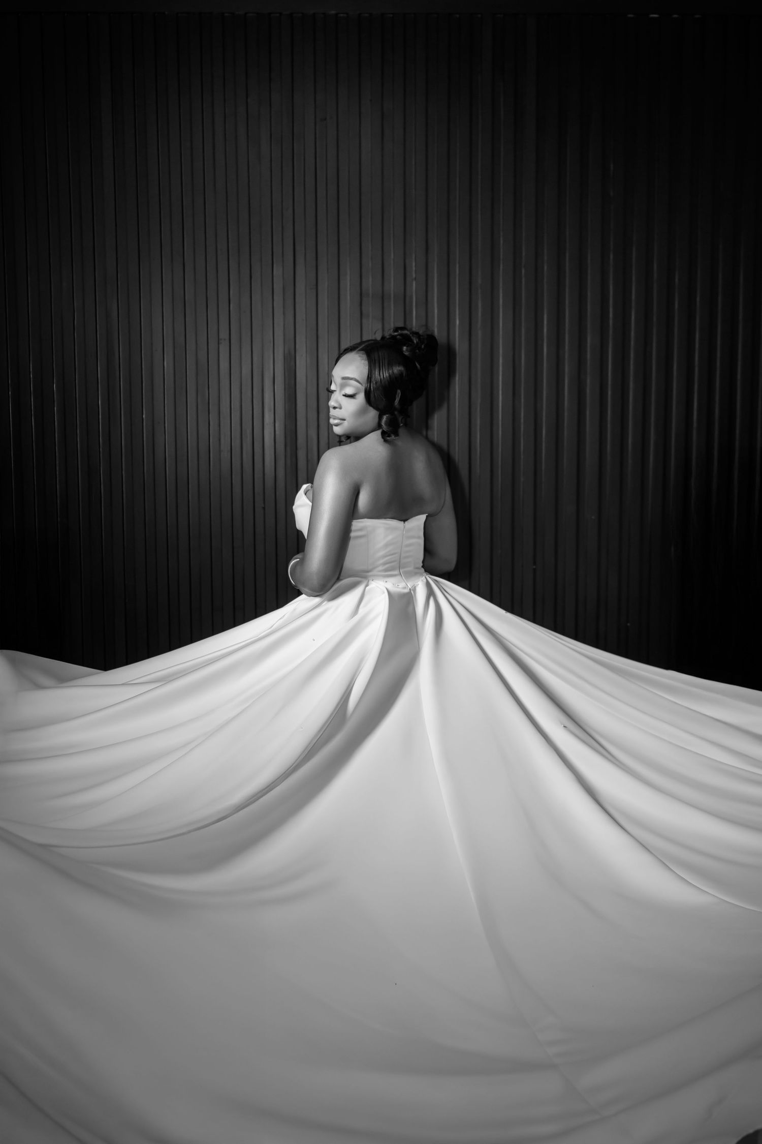 A black and white sequence showing a white fabric being twirled and flowing in a dramatic spinning motion against dark background.