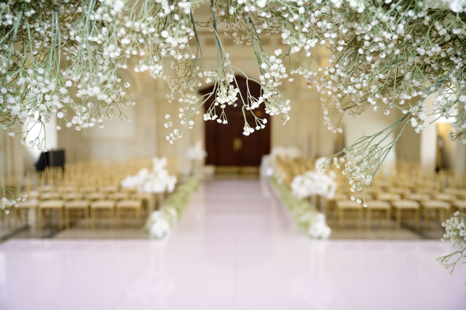 Wedding venue decorated with delicate baby's breath flowers and white drapery.