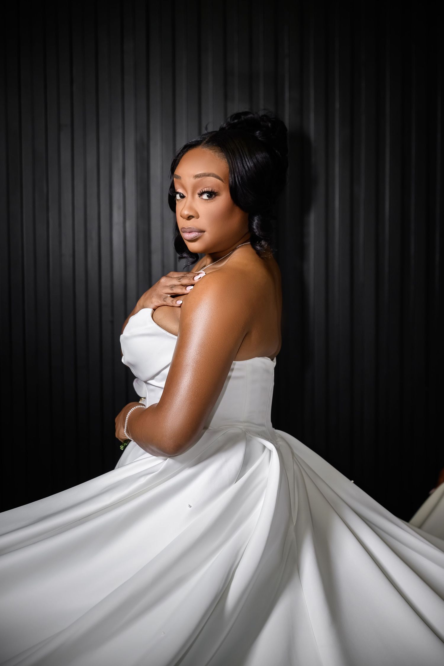 A dramatic black and white portrait series shows a woman in a flowing white gown against a dark striped background.