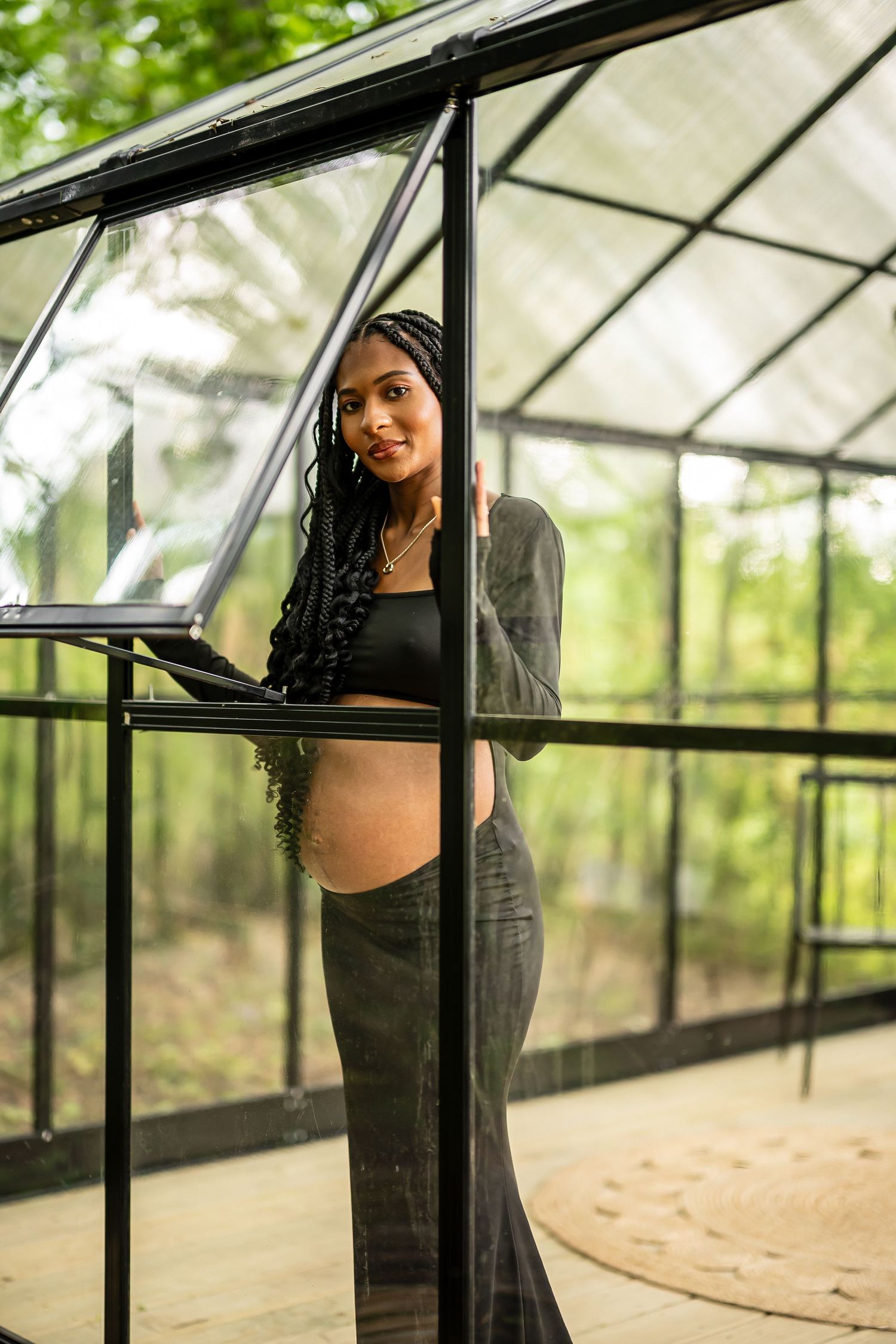 Greenhouse photography session with natural lighting streaming through glass panels.