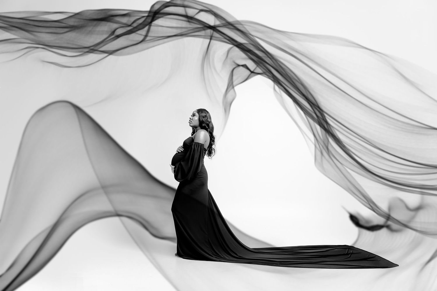 Abstract black and white smoke patterns creating flowing curves and waves against white background.