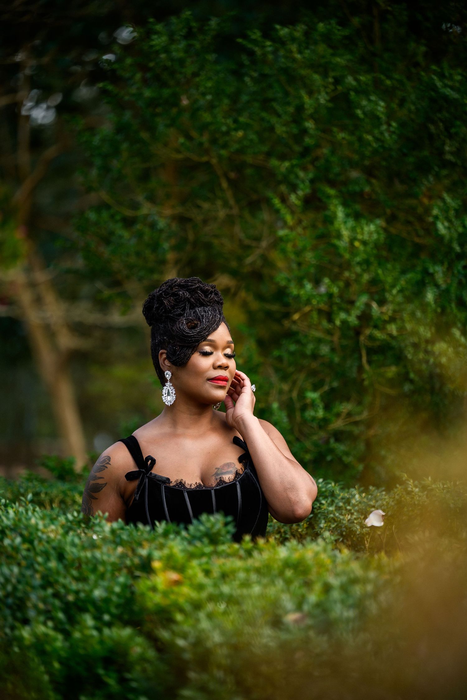 Artistic portrait series in a lush garden setting with natural greenery and bokeh effects in the background.
