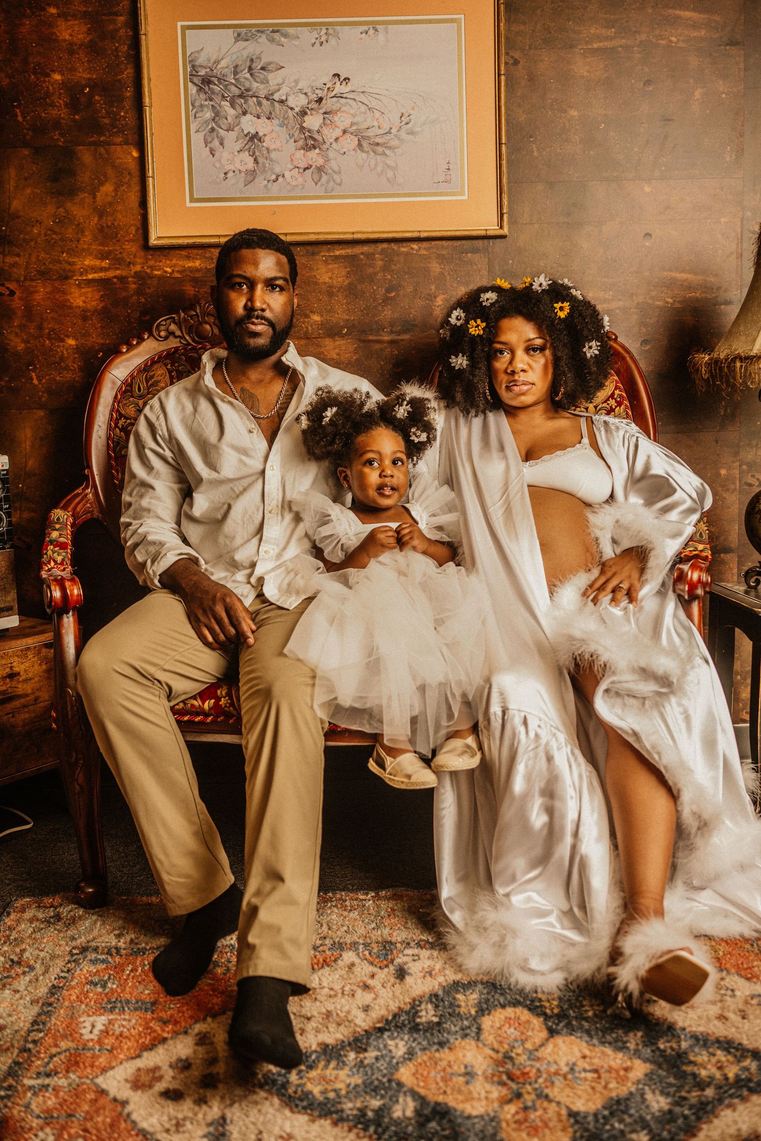 Family portrait series with white outfits against rustic wood wall and vintage decor.