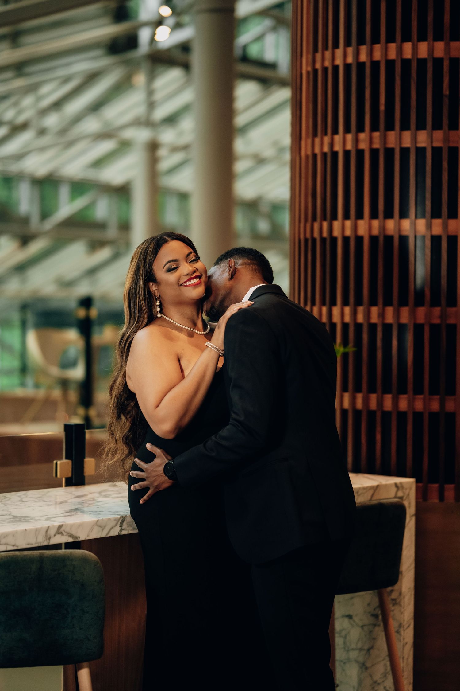 Intimate moment between couple in formal wear near architectural columns.