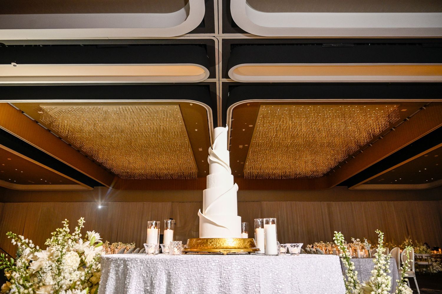 Modern wedding venue decorated with dramatic lighting and floral arrangements.