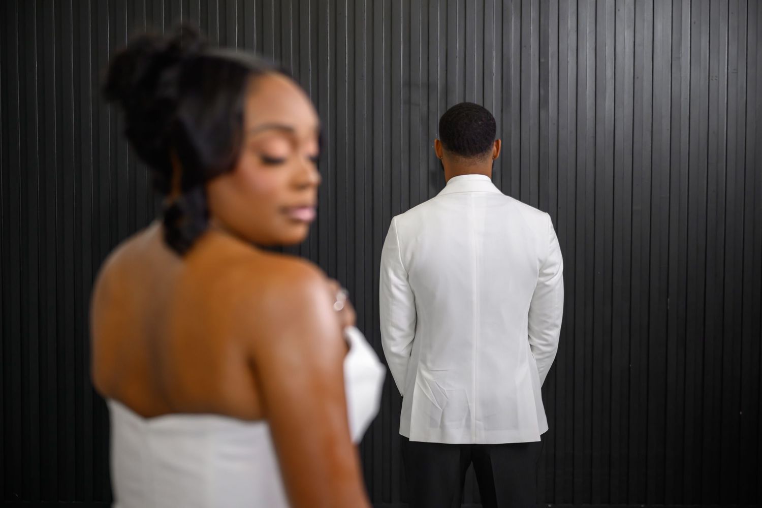 A couple in formal wedding attire poses together in a black and white artistic photo series.