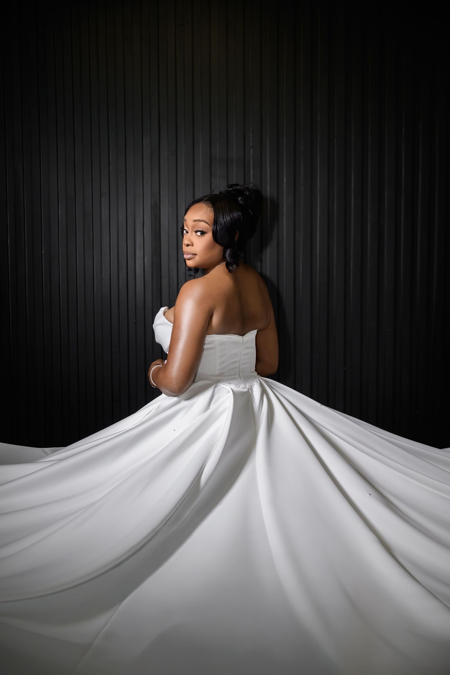 A dramatic sequence of a bride in a white wedding dress against a dark backdrop creating an elegant flowing silhouette.