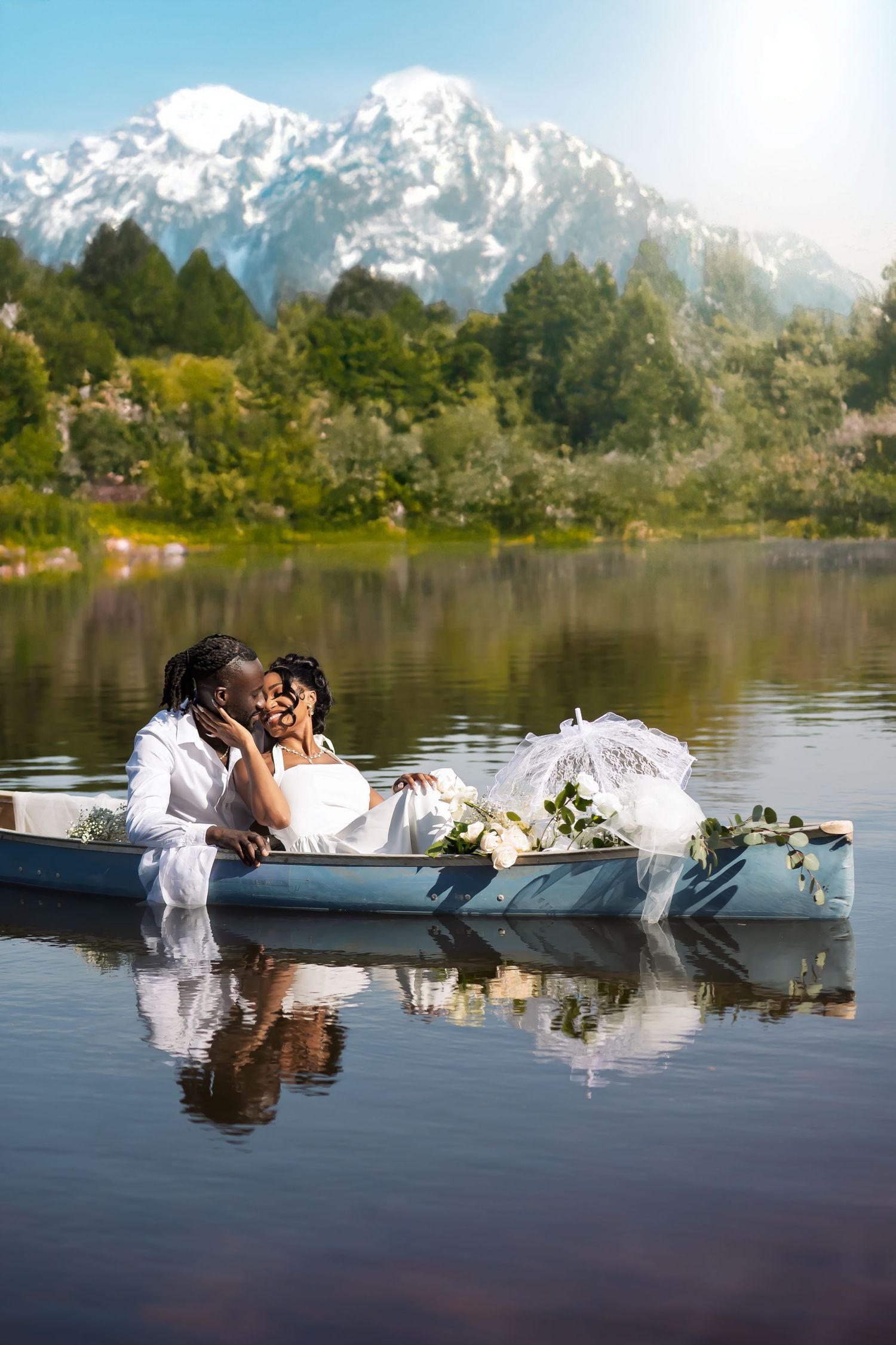 Wedding couple embraces in canoe on serene lake with snow-capped mountains in background.