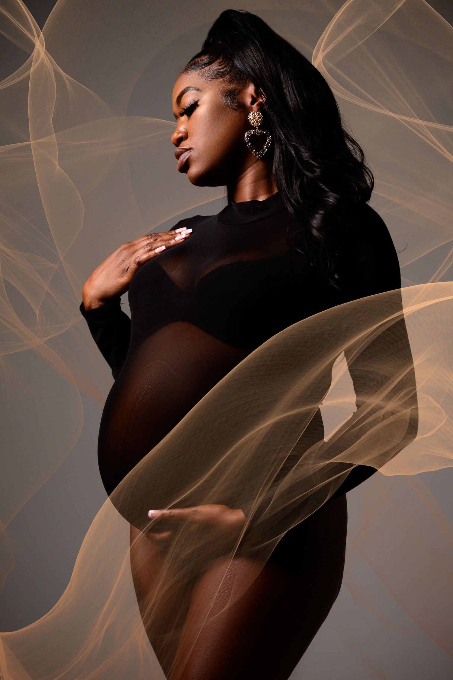 Dramatic portrait series with sheer golden fabric creating ethereal effect against dark background.