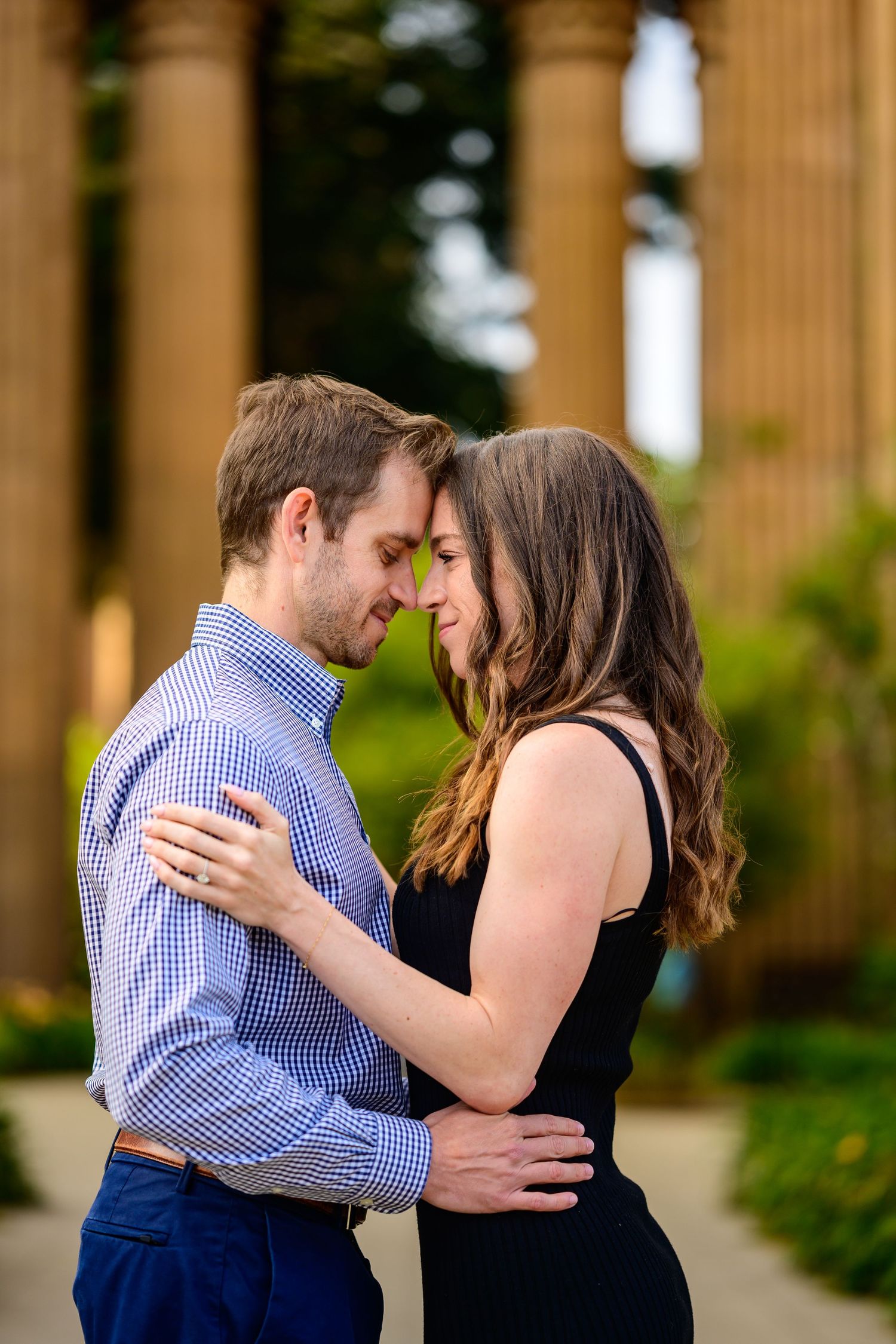 A romantic sequence captured under classical columns showing an embracing couple.