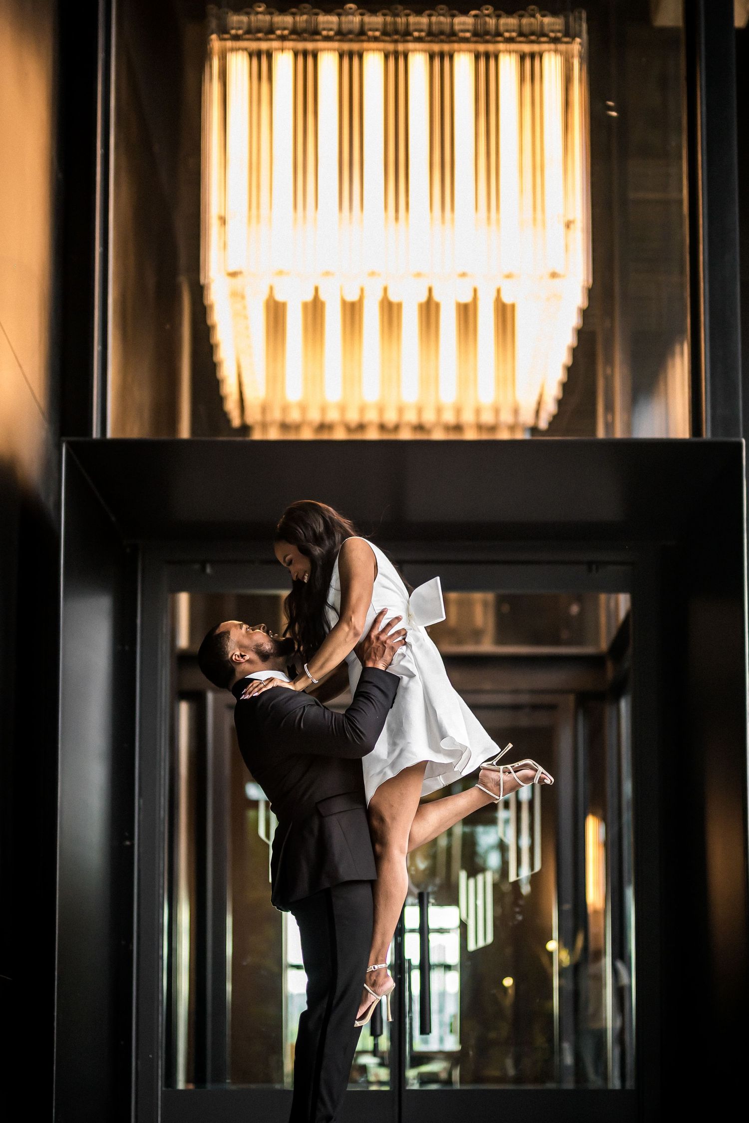 Dramatic indoor portrait with golden backlighting and elegant architecture.