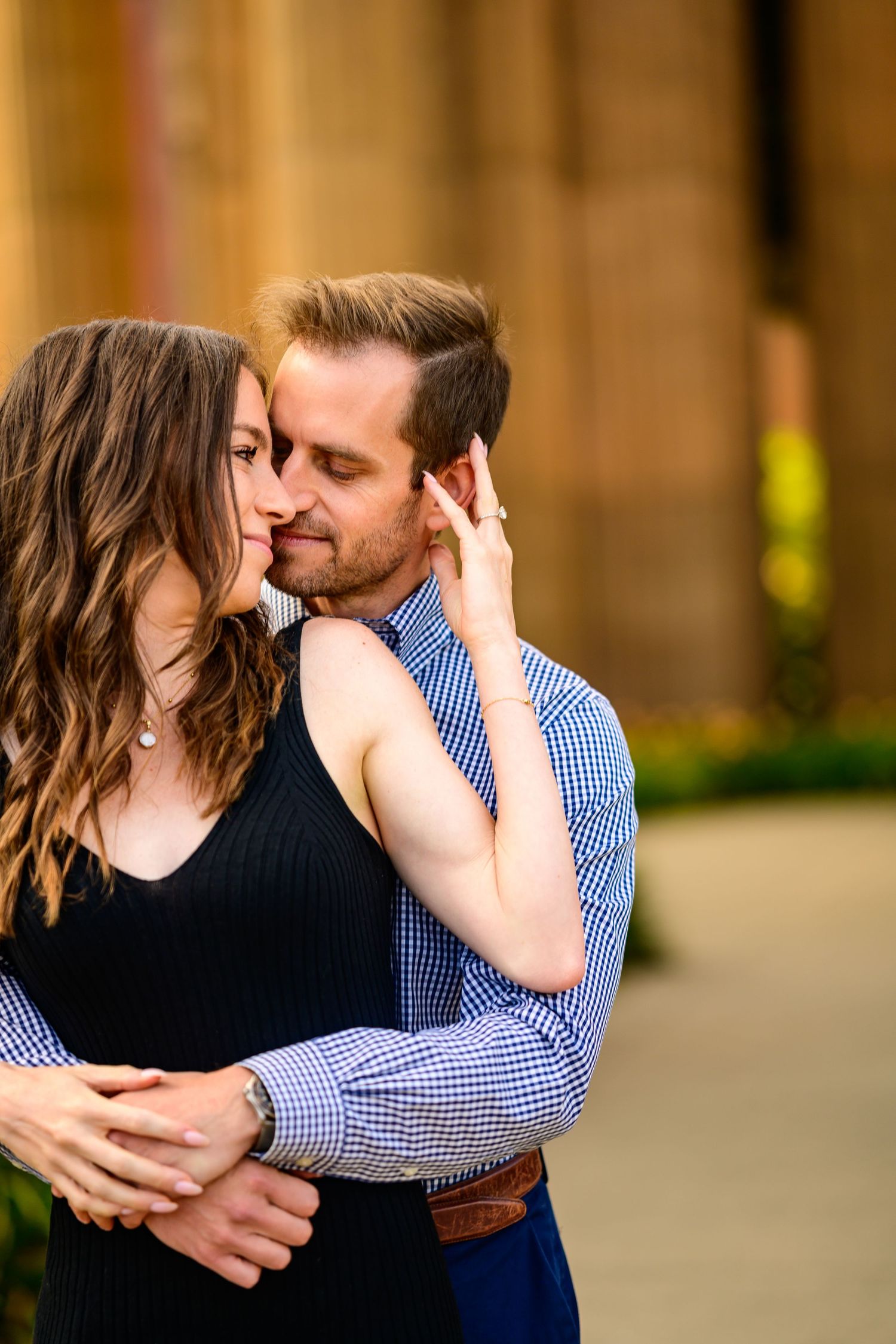 A romantic engagement photo series showing tender moments between a couple near classical architecture.