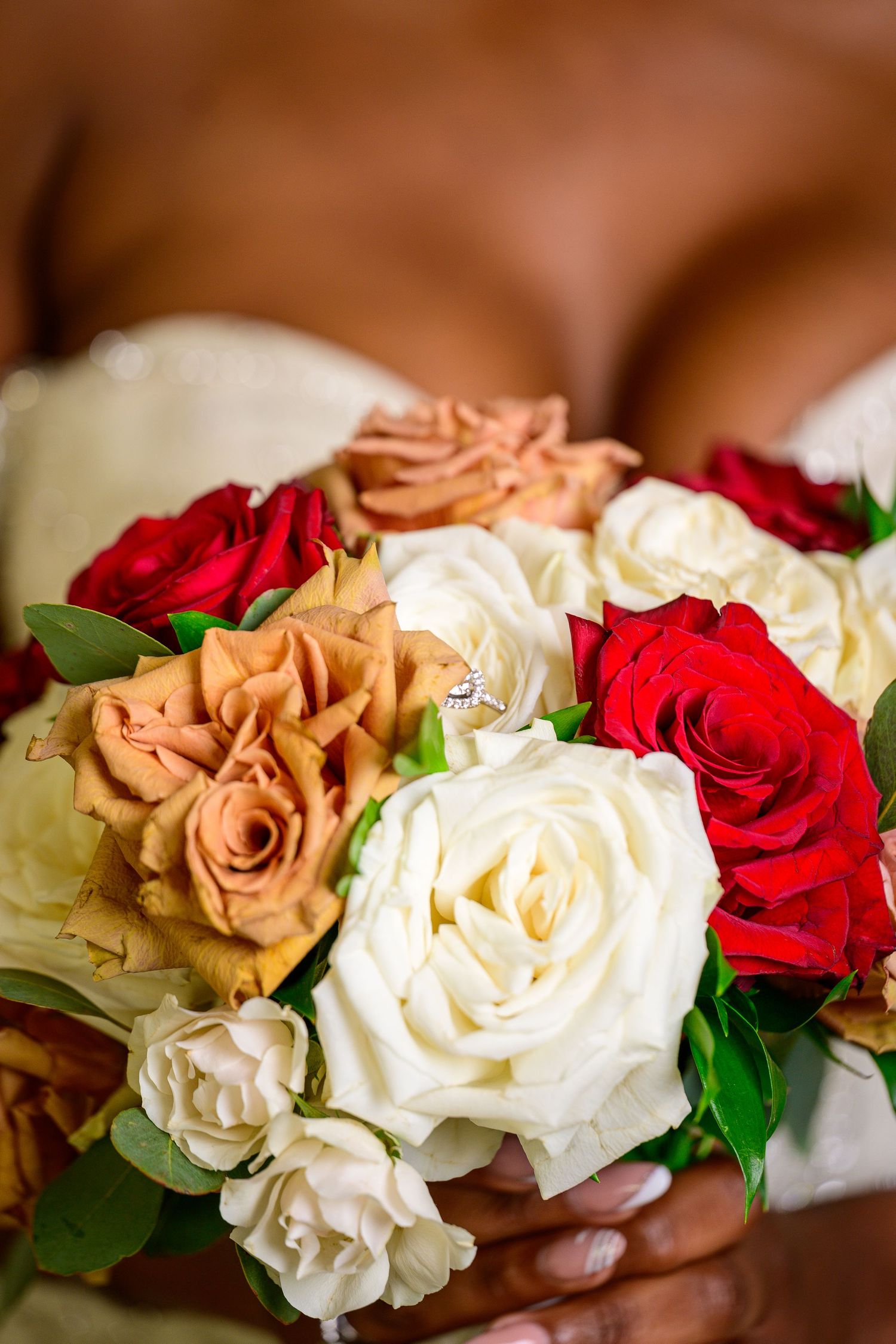 Elegant bouquet featuring red, white and peach colored roses with green foliage.