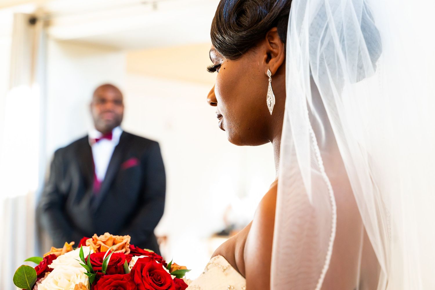 Beautiful wedding ceremony with red and white floral arrangements and decor.