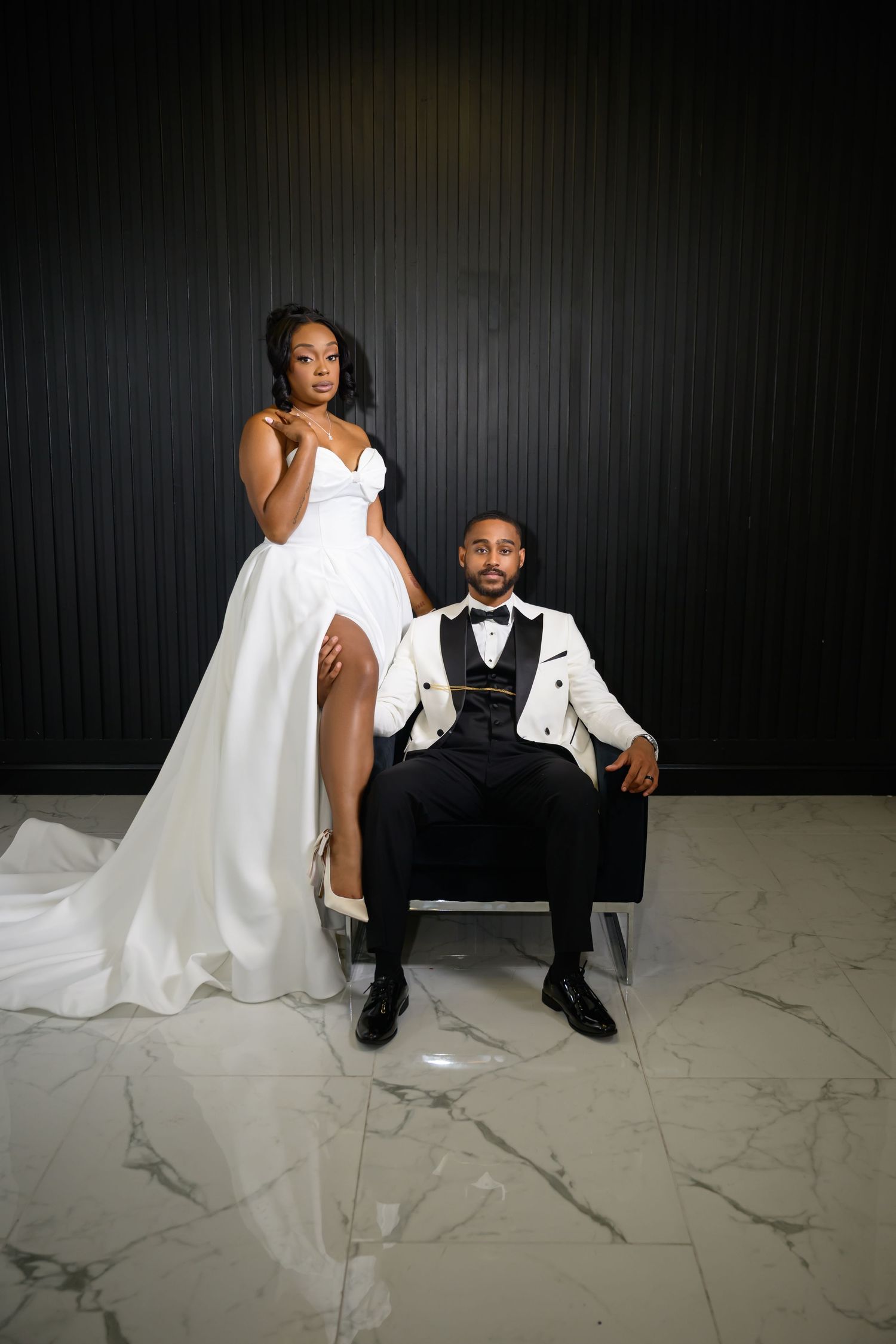 A couple in formal wedding attire poses on a marble floor against a dark backdrop in a series of artistic photos.