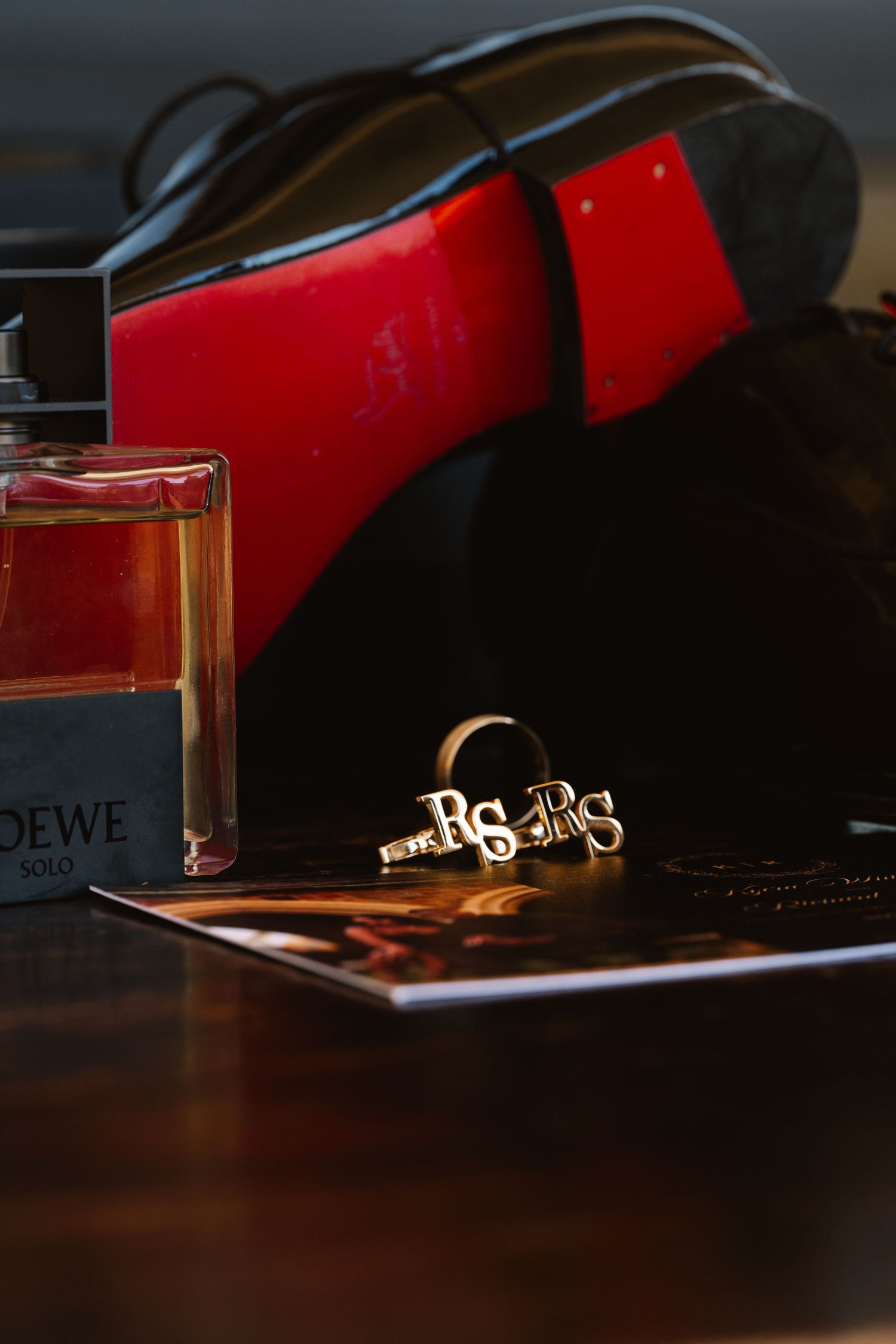 Artistic still life of jewelry and accessories against dark background with red accent lighting.