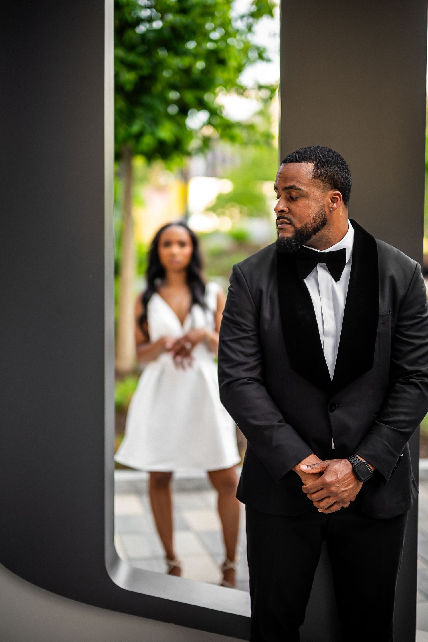 Formal wedding portraits in modern architectural setting with black and white contrast.