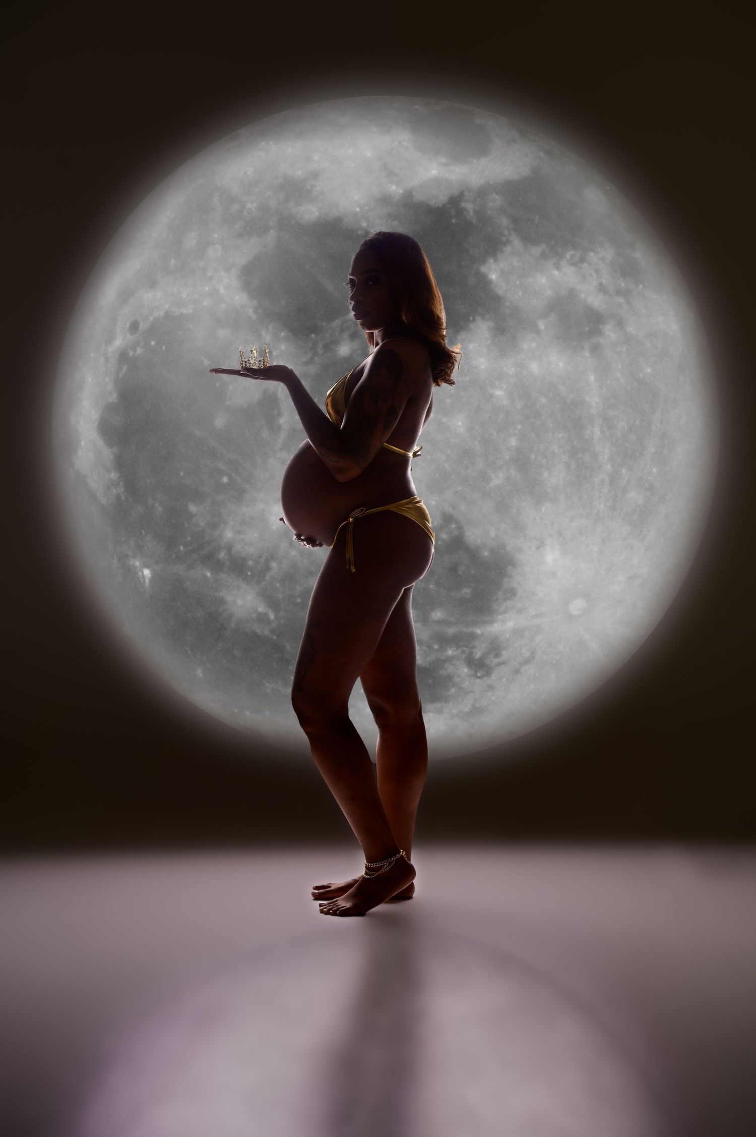 Silhouette dance poses against large moon backdrop creating dramatic theatrical effect.