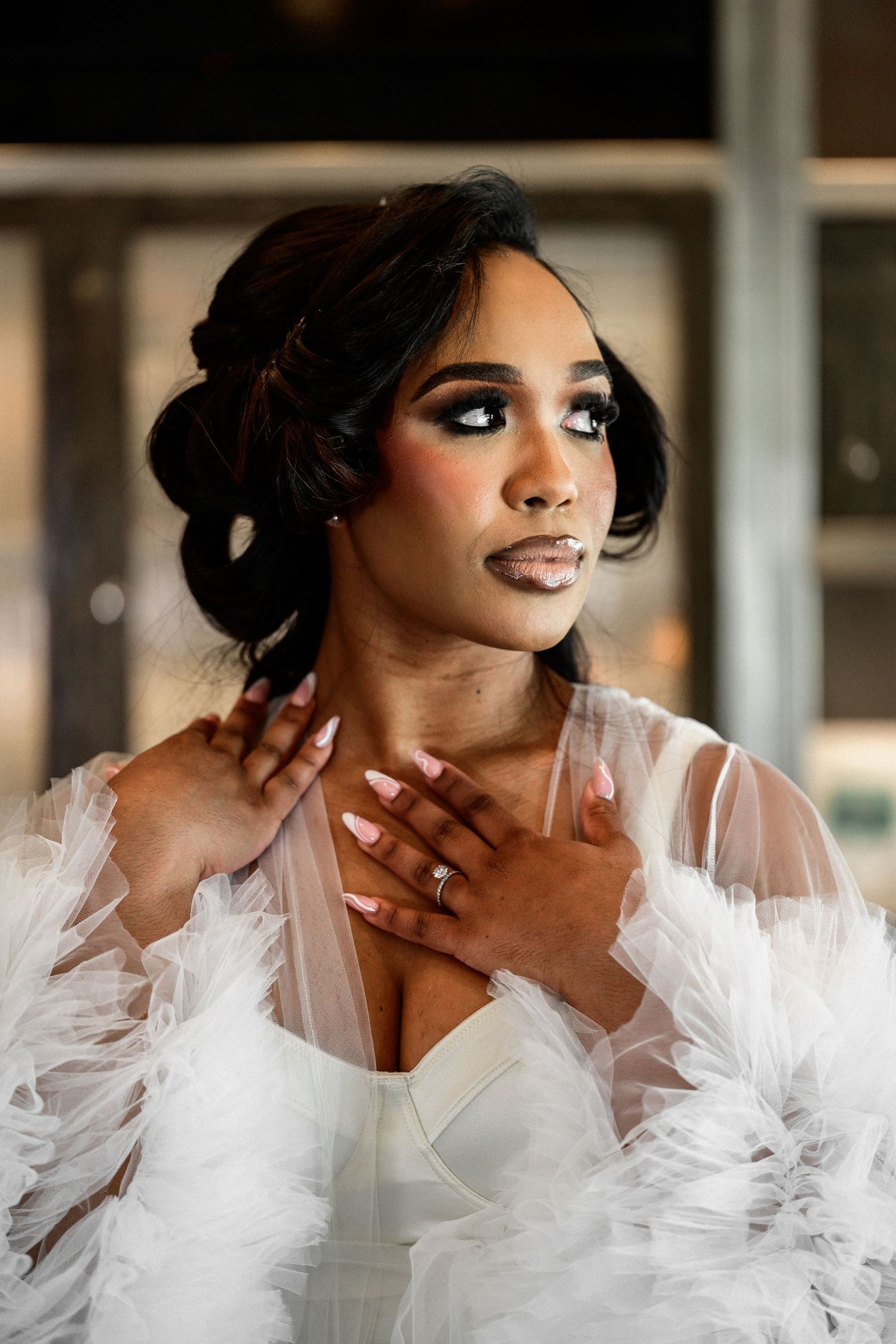 Glamorous bridal portrait with dramatic white tulle and elegant makeup.
