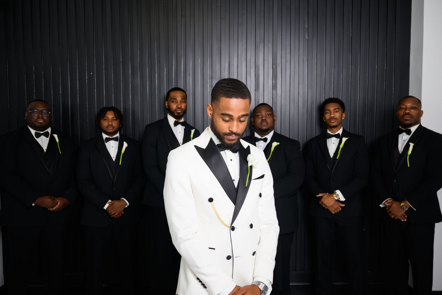 A group of people in formal black and white attire pose together at an elegant event.