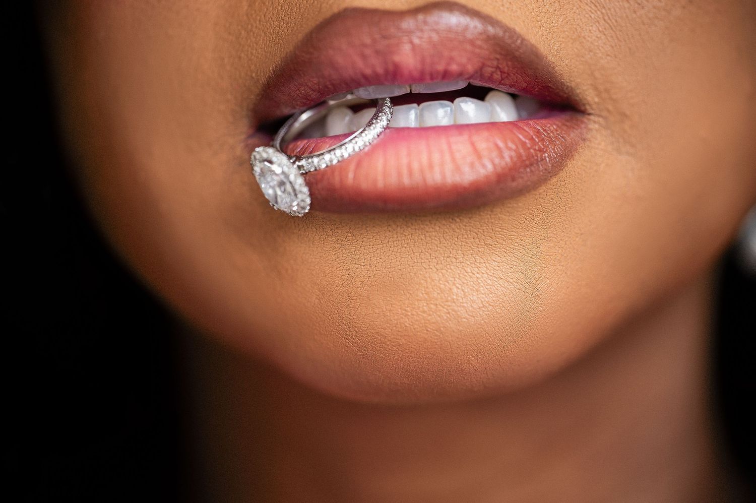 Artistic macro shot focusing on glossy lips and sparkling jewelry details.