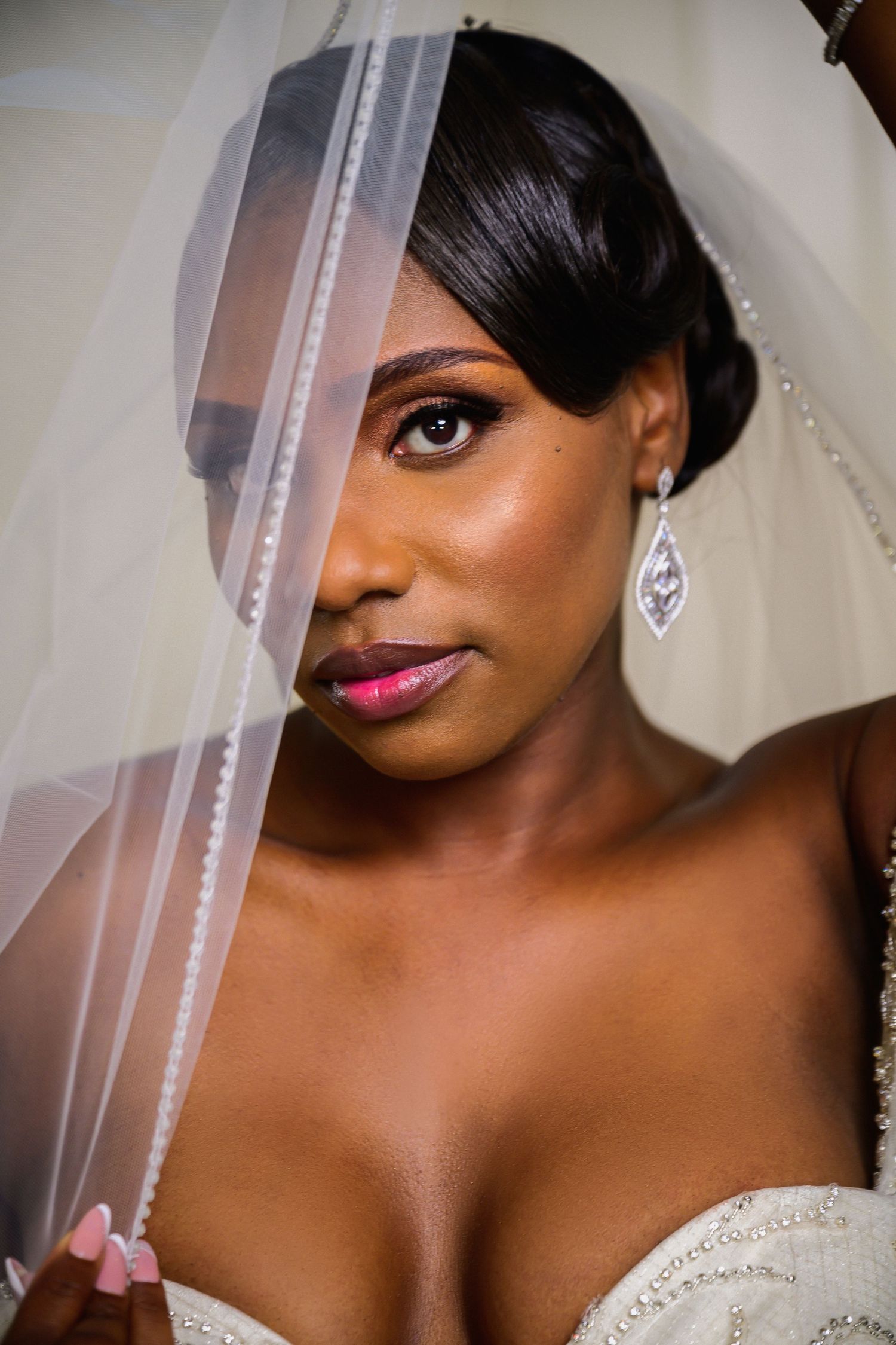 Close-up bridal portrait showcasing delicate veil and diamond earrings.