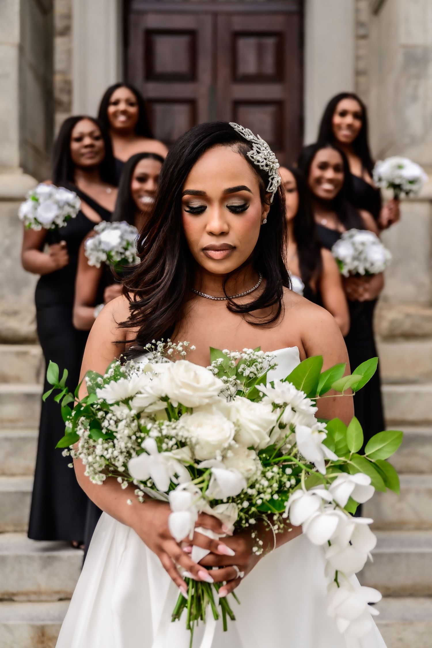 Close-up of elegant white and green bridal bouquet with lilies and greenery.