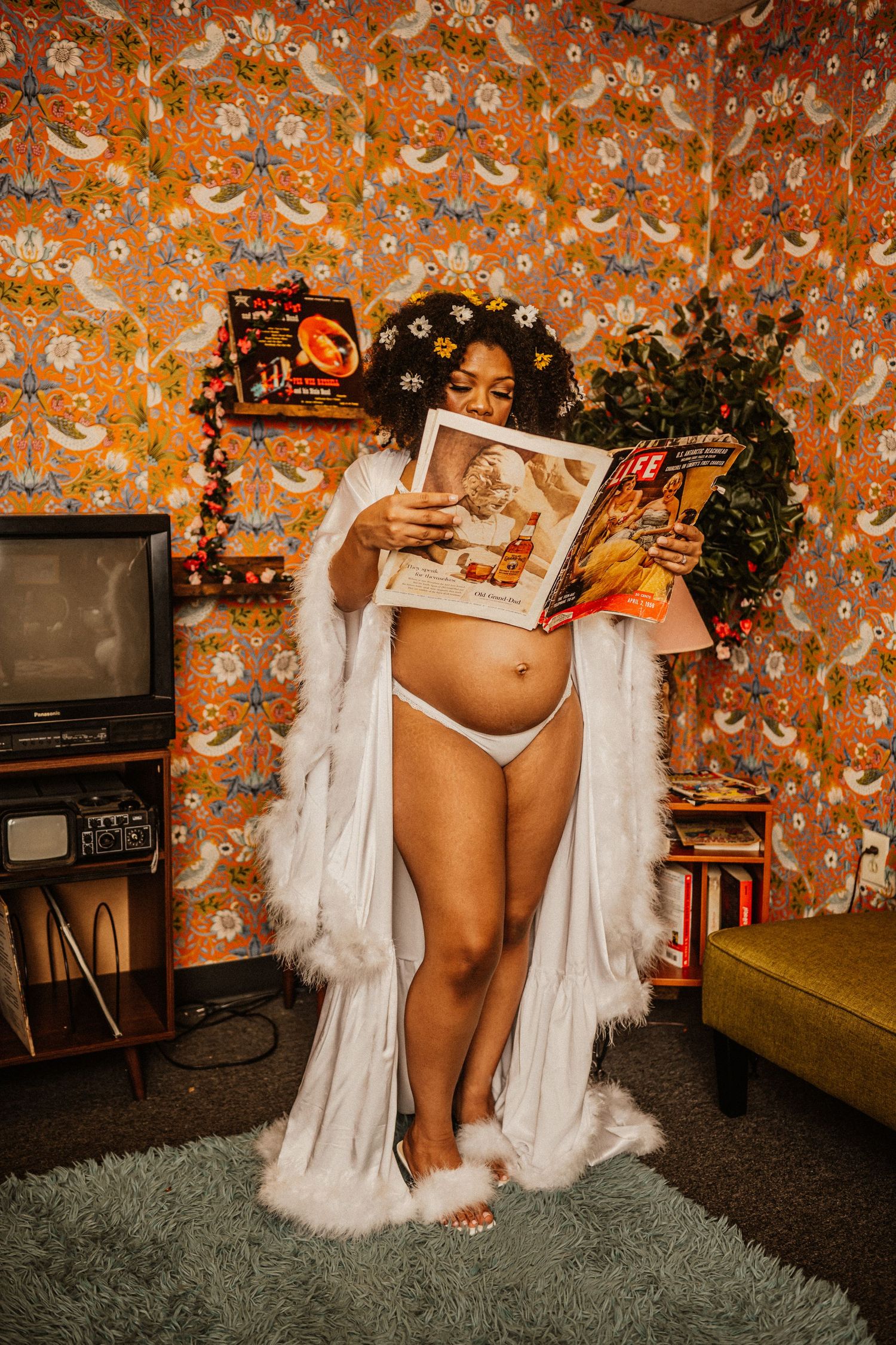 Artistic maternity photo sequence against orange floral wallpaper showing white flowing fabric and intimate details.