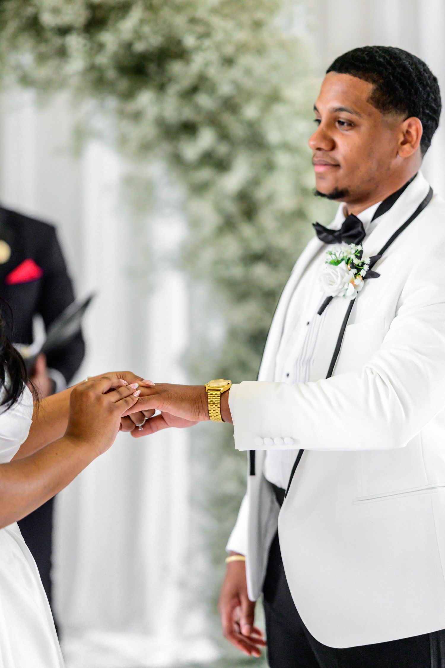 Wedding party members in white tuxedos pose during formal portraits.
