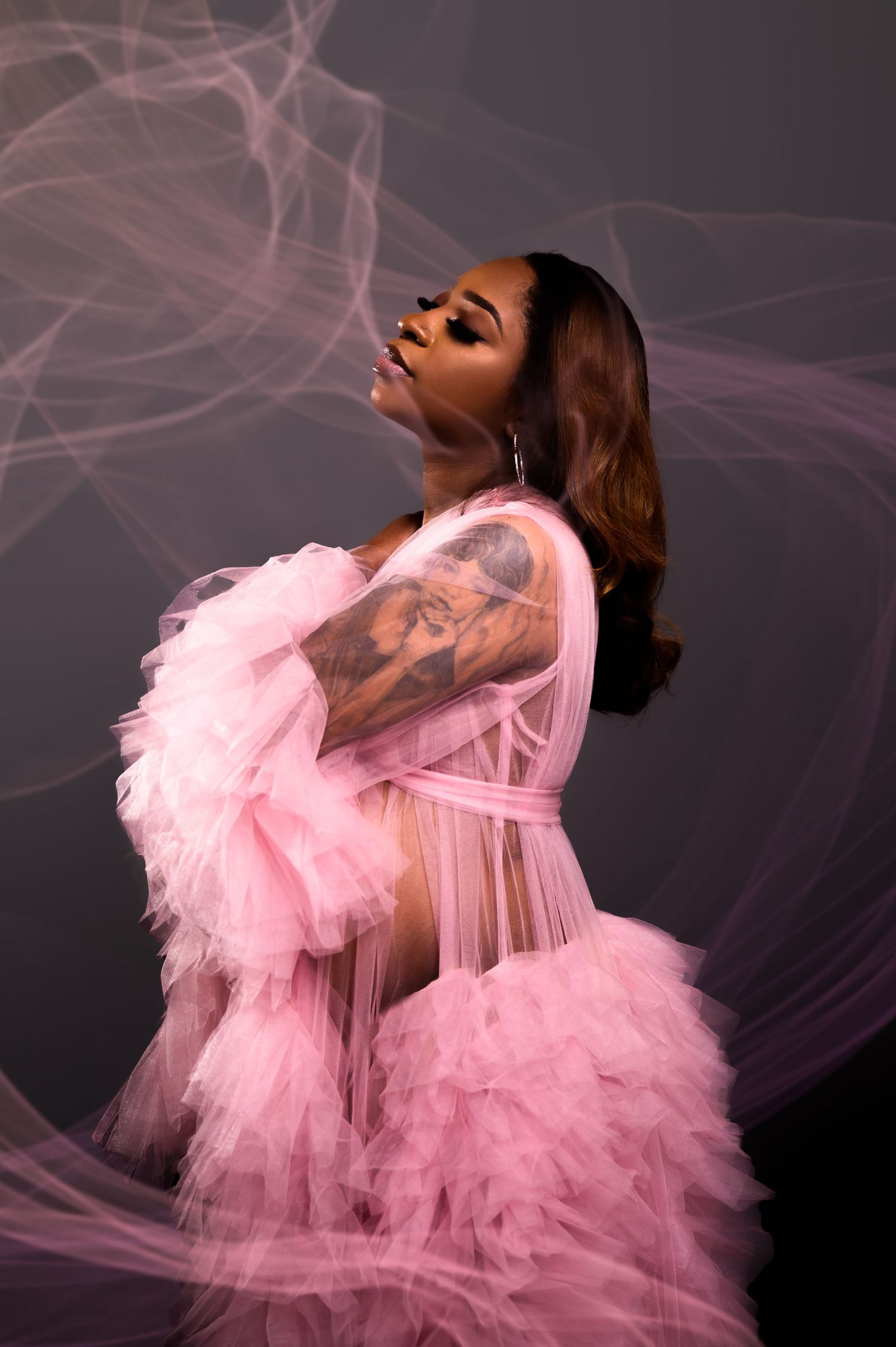 Artistic portrait series featuring flowing pink tulle fabric against dark background creating ethereal movement.
