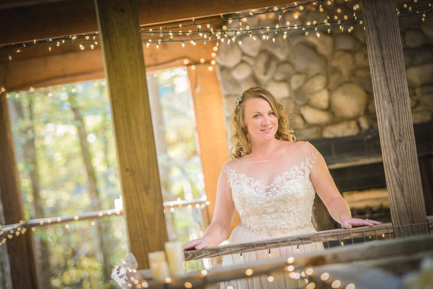 A wedding portrait captured on a rustic wooden porch decorated with twinkling lights during golden hour by Gatlinburg Wedding Photographers.